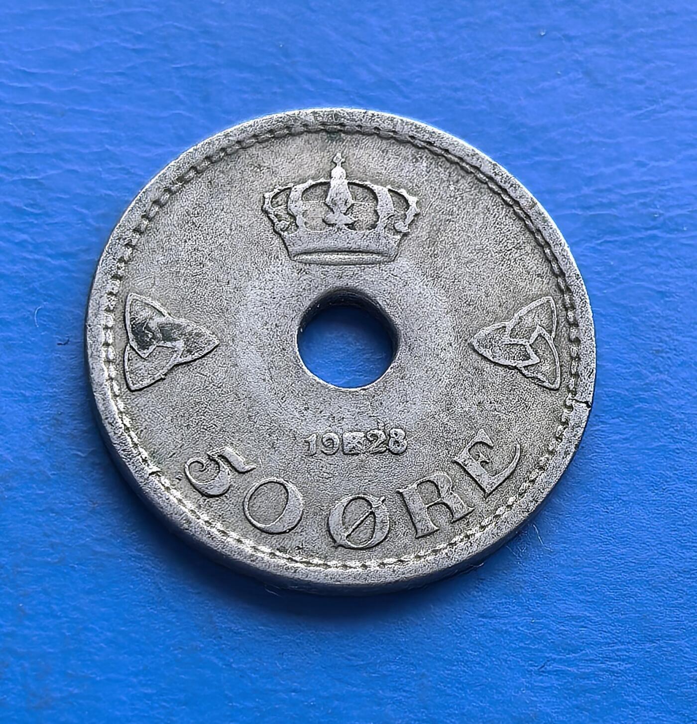 外国优质老铜币高银银币，周六九点倒数截拍，满百包邮，持续收拍 1928 年丹麦 50 欧尔圆孔币，正面皇冠与凯尔特结彰显王室符号，背面十字纹章具北欧传统韵味。近百年包浆，设计独特，承载丹麦货币史脉络，是北欧文化与钱币收藏的特色标本 。