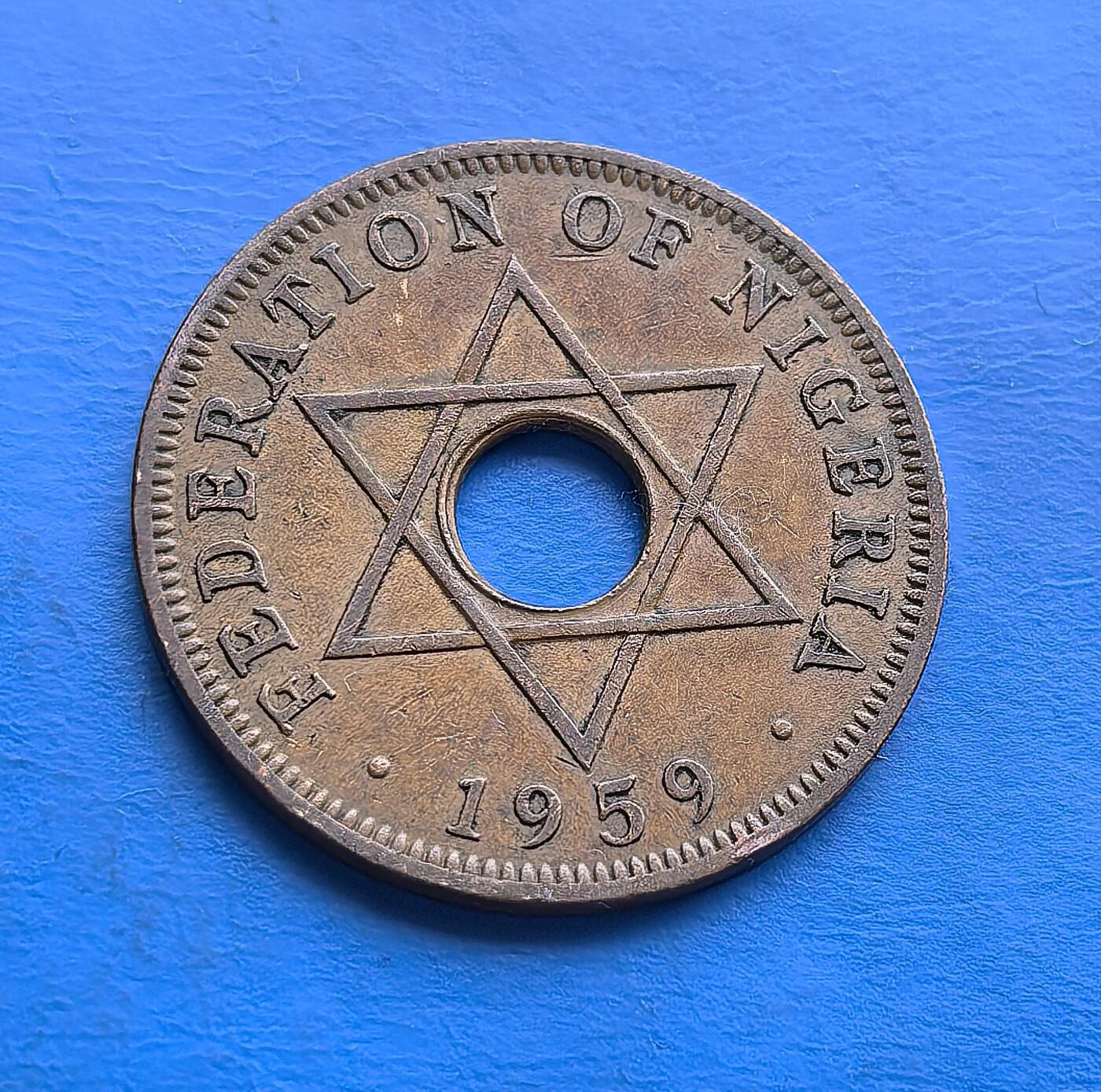 外国优质老铜币高银银币，周六九点倒数截拍，满百包邮，持续收拍 尼日利亚 1959 年1 便士，属独立前殖民过渡时期。中间圆孔设计独特，背面六角星象征联邦，币面融合英女王与本土符号，见证国家历史转折。青铜包浆古朴，是非洲殖民币收藏中承载时代脉络的特色藏品 。