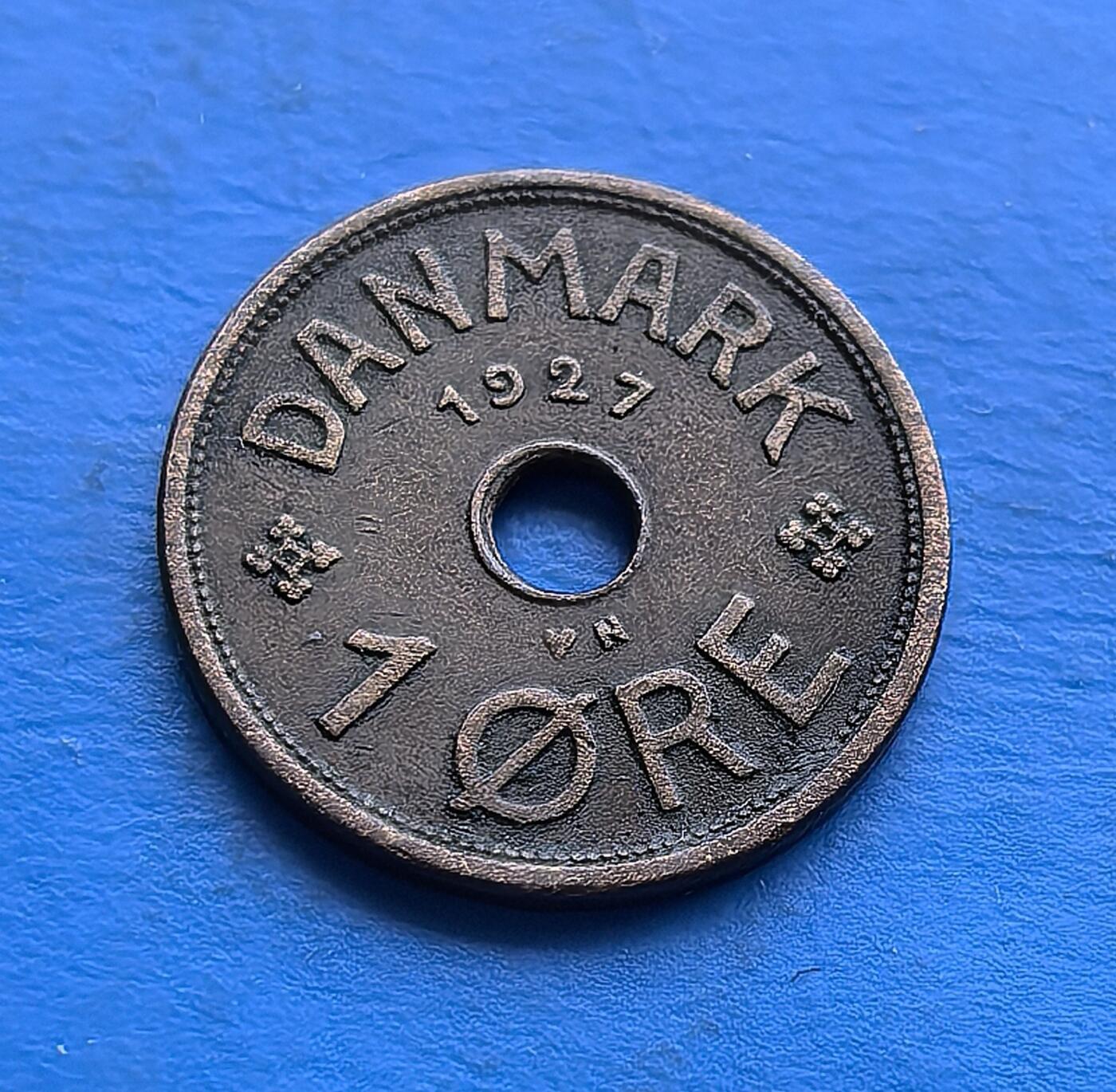 外国优质老铜币高银银币，周六九点倒数截拍，满百包邮，持续收拍 丹麦1927年1 欧尔青铜圆孔币，发行于克里斯蒂安十世统治期（二战前和平阶段）。正面饰王室花押与皇冠，背面镌 “DANMARK”、年份及面值，圆孔设计独特。青铜包浆厚重，见证战前丹麦货币工艺，是北欧君主制钱币收藏的经典标的，承载早期王室货币的历史韵味 。