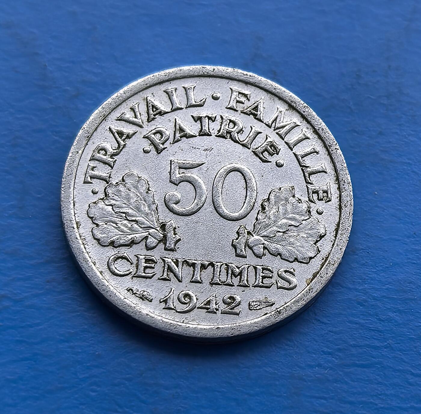 外国优质老铜币高银银币，周六九点倒数截拍，满百包邮，持续收拍 少见束棒星星清晰可见，1942 年维希法国 50 生丁铝币，诞于二战沦陷期。正面 “工作・家庭・祖国” 投射政权理念，背面斧与麦穗是维希标识。铝质包浆藏战时痕迹，见证被占区货币生态与政治符号。作为二战特殊标本，亲民可藏，助解码法国战时复杂脉络，是战争史与货币藏家的独特标的 。