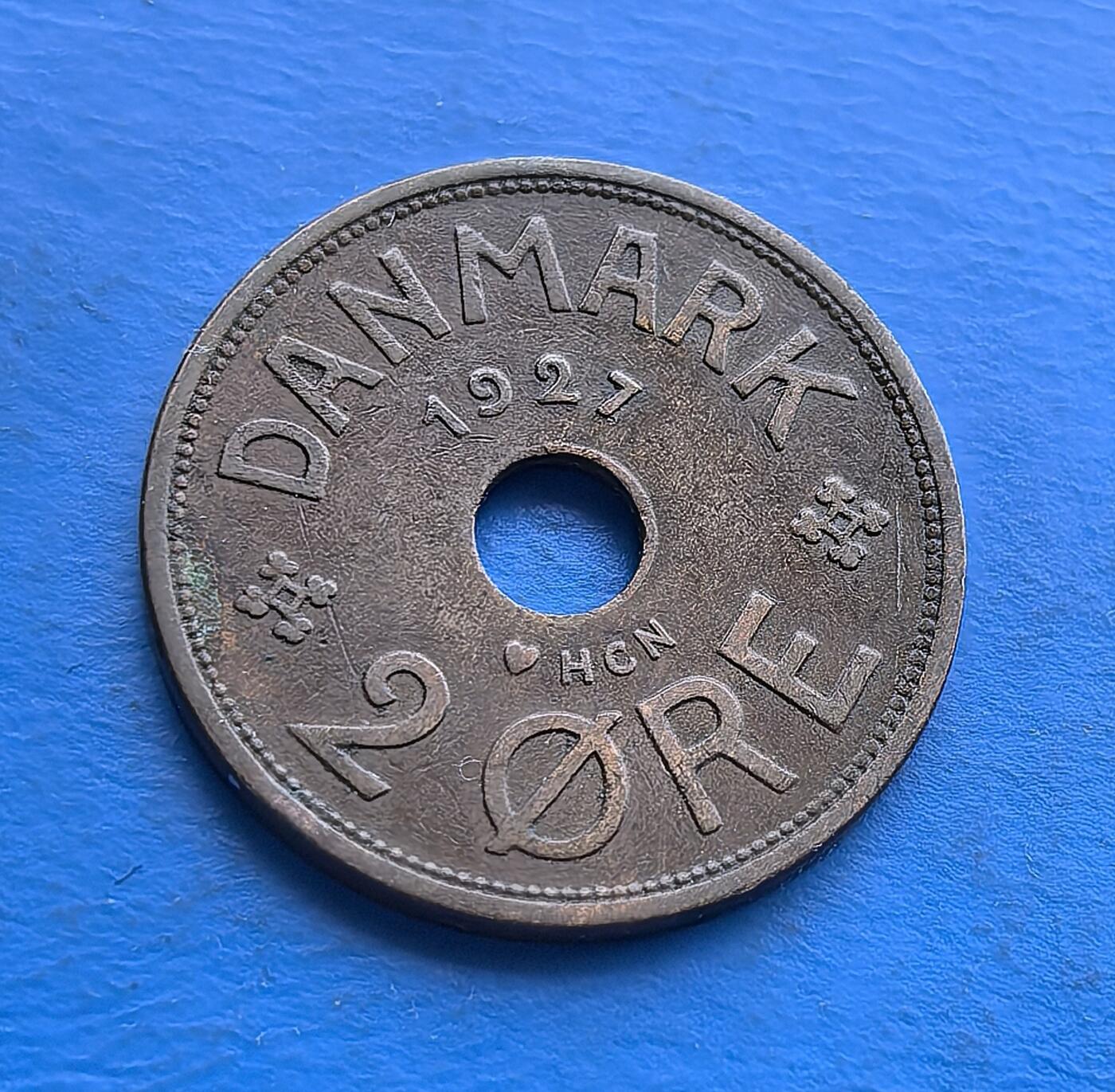 外国优质老铜币高银银币，周六九点倒数截拍，满百包邮，持续收拍 丹麦1927 年2 欧尔青铜圆孔币，发行于克里斯蒂安十世统治期（二战前和平阶段）。正面饰王室花押与皇冠，背面镌 “DANMARK”、年份及面值，圆孔设计独特。青铜包浆厚重，见证战前丹麦货币工艺，是北欧君主制钱币收藏的经典标的，承载早期王室货币的历史韵味 。