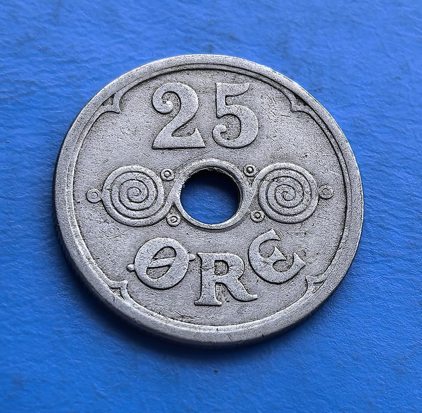 外国优质老铜币高银银币，周六九点倒数截拍，满百包邮，持续收拍 丹麦1930 年 25 欧尔圆孔币，铸于大萧条前夜。正面螺旋纹配圆孔，设计复古别致；背面君主花押（CXR）与皇冠，彰显王室符号。铜镍质地包浆自然，承载战前丹麦货币审美。作为克里斯蒂安十世时期实物，亲民门槛，适配欧洲古币藏家，解码 20 世纪初北欧王室与经济脉络，是小众币藏的特色标的 。