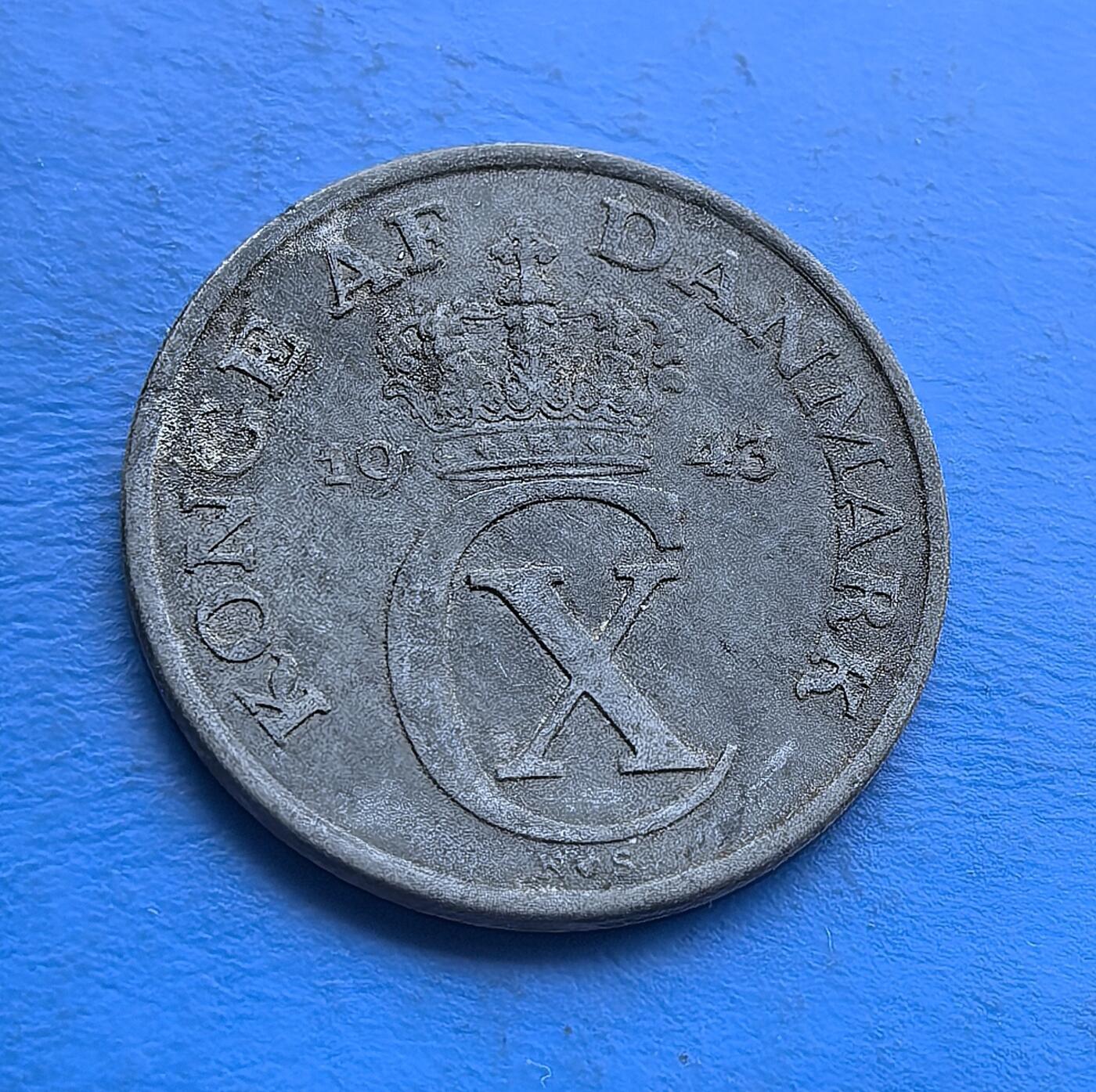 外国优质老铜币高银银币，周六九点倒数截拍，满百包邮，持续收拍 丹麦1943 年5 欧尔硬币，发行于二战丹麦被占领时期，承载特殊历史背景。背面饰克里斯蒂安十世王室纹章（皇冠、花押），正面橄榄枝环绕面值，北欧风格鲜明。近百年包浆厚重，兼具历史纪念性与设计美感，是二战货币、丹麦王室题材收藏的特色标的 。