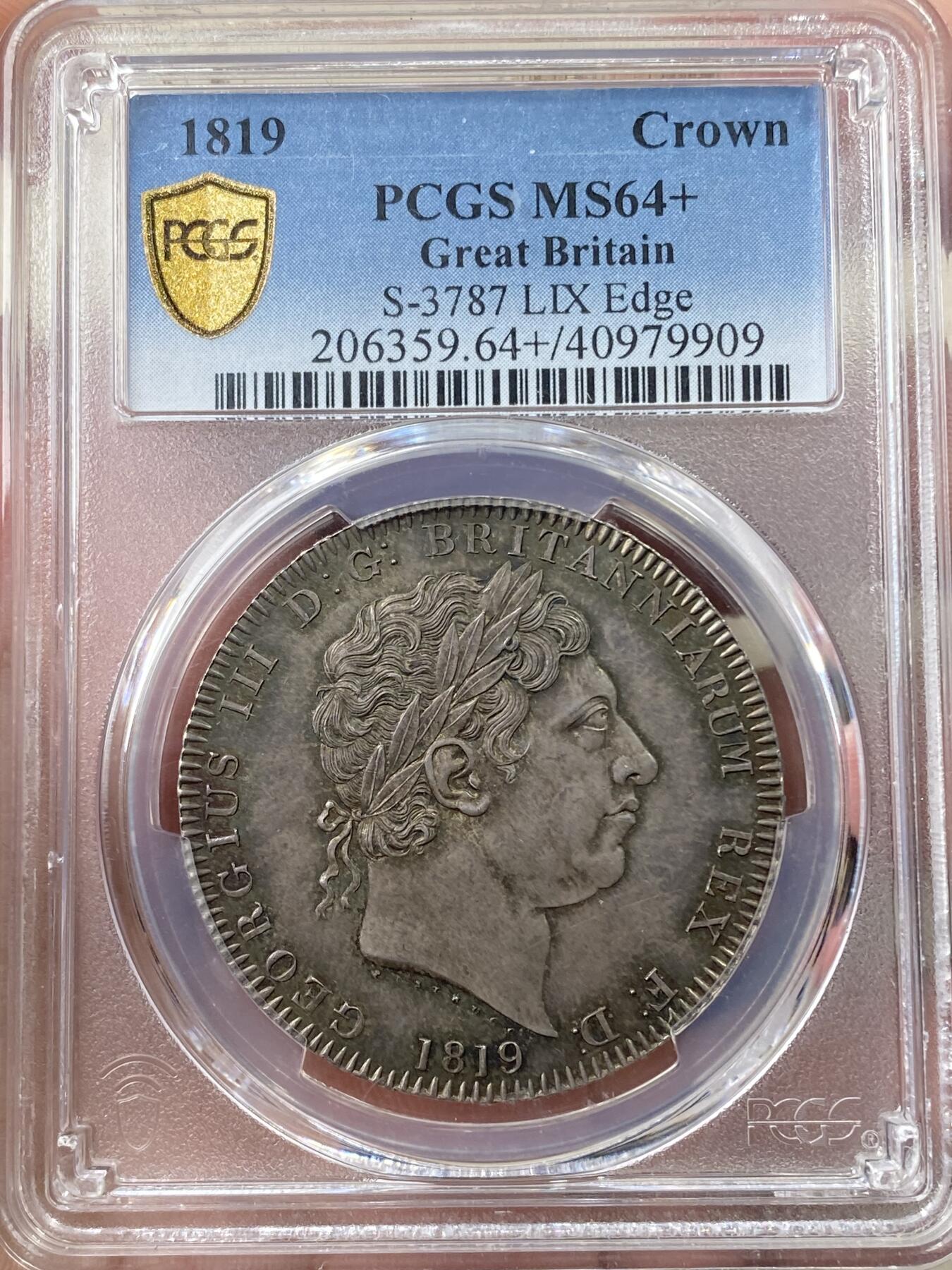 万国钱币拍卖第058期（万国新年大拍） PCGS MS64+ 1819年LIX英国乔治三世马剑克朗大银 英国马剑系列的开山之作 马剑图案由著名的意大利雕刻家Pistrucci设计 在钱币两面皆留下签名 这在当时是难以被接受的（通常只留首字母缩写） 此举也为后来首席雕刻师W.Wyon上位埋下伏笔 此枚无论底板，包浆，还是高点都堪称无可挑剔  一枚乔三马剑的标准器  高分价格越来越看不懂的存在 此次贴脸入手机会切勿错过