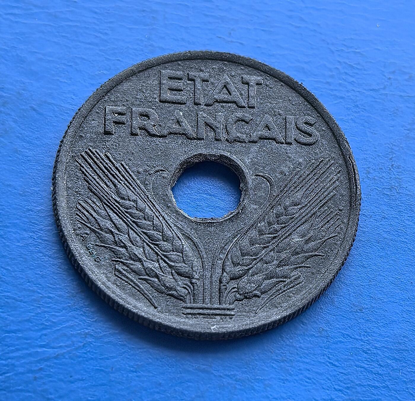 外国优质老铜币高银银币，周六九点倒数截拍，满百包邮，持续收拍 维希法国1942 年 20 生丁圆孔币，铸于二战沦陷期。正面 “ETAT FRANCAIS” 彰显政权符号，背面橡叶环护面额，圆孔设计因物资匮乏而生。劣质材质凝岁月痕，承载战时经济困局与维希时代印记，是二战被占区货币的微观标本，亲民门槛解码法国黑暗岁月的货币脉络 。
