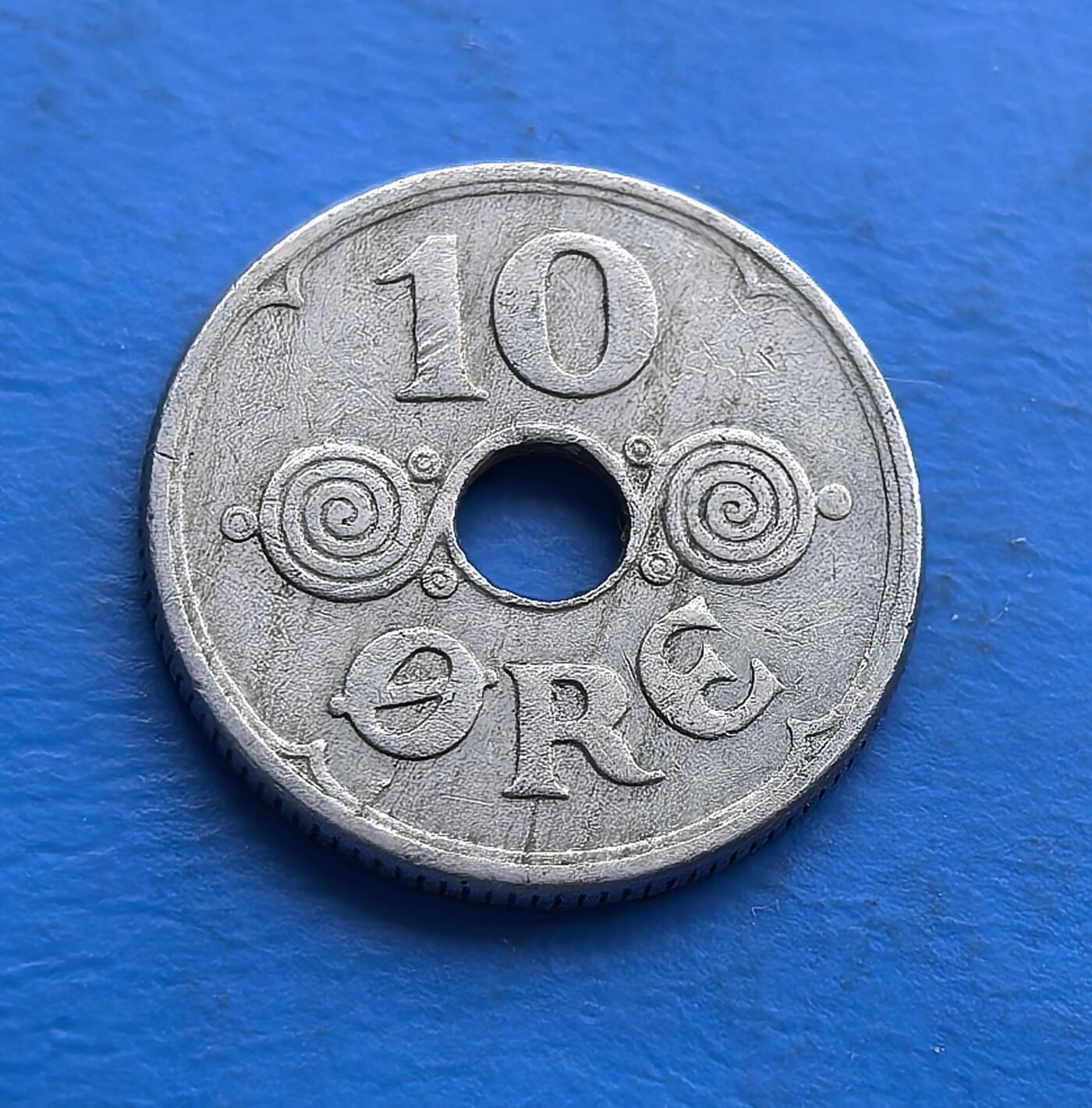 外国优质老铜币高银银币，周六九点倒数截拍，满百包邮，持续收拍 丹麦1940 年10 欧尔圆孔币，铸于二战占领伊始。正面螺旋纹配圆孔，设计复古；背面君主花押（CXR）与皇冠，暗喻王室存续。铜镍包浆凝战时初痕，见证中立国沦陷瞬间。作为被占首年货币，承载战争开端记忆，亲民门槛，适配战争史与北欧币藏，解码战时王权与货币的微妙博弈 。