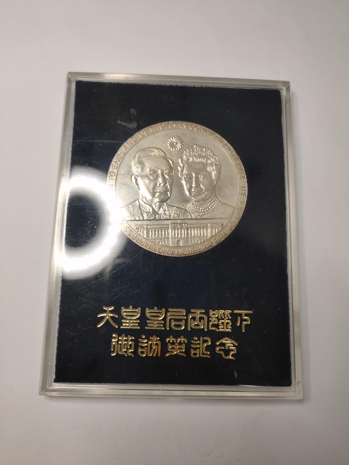 银质纪念章，直径约60mm，重约62克，带原装盒。正面为英国女王伊丽莎白二世和爱丁堡公爵，背面为日本天皇和皇后，纪念1971年日本天皇夫妇访问英国。银质材质，浮雕工艺，细节清晰，保存状态极佳，几乎全新，原配盒无明显磨损