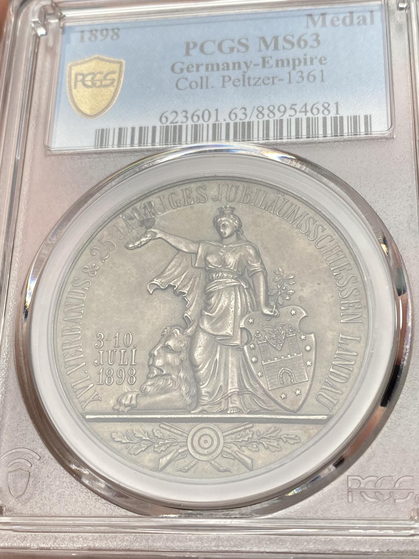 万国钱币拍卖第058期（万国新年大拍） PCGS MS63 1898年德国巴伐利亚兰道-普法尔茨第十六届射击节暨25周年纪念银章 冠军分罕见小邦射击节 正面:日耳曼妮娅女神右手举着胜利桂冠，左手持橡树枝，靠在兰道城市纹章盾徽上，巴伐利亚雄狮趴在她的脚边，底部是射击节标志。背面:王冠，巴伐利亚-兰道-普法尔茨的盾徽，底部是群山中的城市景观，朝阳升起。鸟瞰视角，广阔天地跃然章上。微缩雕刻，极其精细。高浮雕磨砂工艺，热门女神德射，自藏佳品。