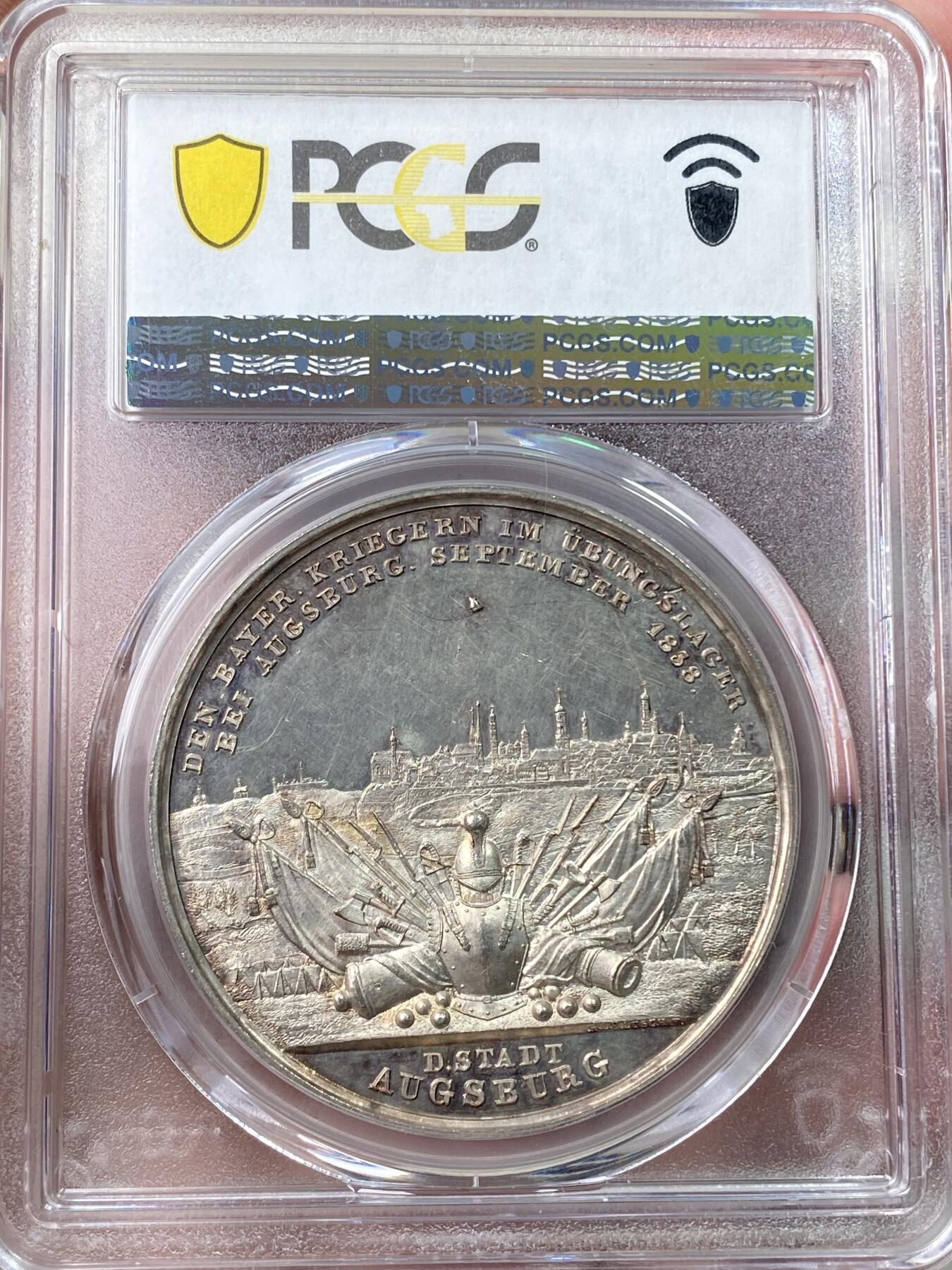 万国钱币拍卖第058期（万国新年大拍） PCGS SP61 1838年德国巴伐利亚路德维希一世奥格斯堡练兵营纪念景观大银章 罕见品种 超高浮雕 正面：拜仁国王路德维希头像 背面：奥格斯堡城市景观，城外原野景观。军营帐篷，各类武器，刀剑枪炮斧，盔甲大炮炮弹。 背面中央镶嵌了一块钴金属 仿佛天外来客 设计巧思 应该是唯一一个使用镶嵌工艺的老银章 亚军分自藏状态合格 高分难遇的品种 