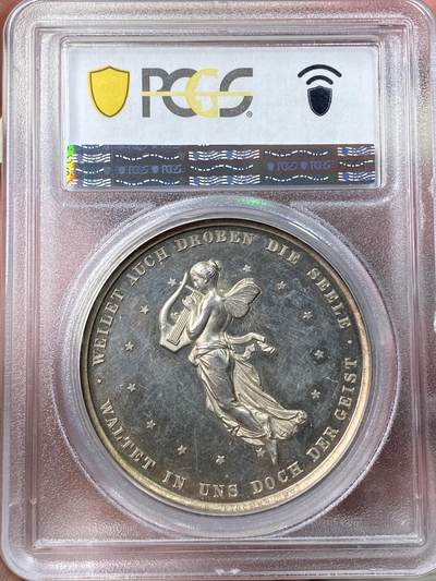万国钱币拍卖第058期（万国新年大拍） PCGS MS63 1859年德国席勒诞辰百年纪念银章 PC唯一评级记录冠军分 稀见品种 43mm 28.8g 精制工艺强镜面，超高浮雕加厚盒。loos工坊大师炫技之作。雕刻细节极佳，人物栩栩如生。实物非常漂亮。正面:桂冠诗人席勒头像。背面:带翼缪斯女神手里拿着竖琴在天空飞行，13颗星星环绕。圣灵守护我们，灵魂也在其中徘徊。天使小翅膀灵动可爱又迷人。欧盟的盟歌欢乐颂为席勒于1785年创作的诗歌。