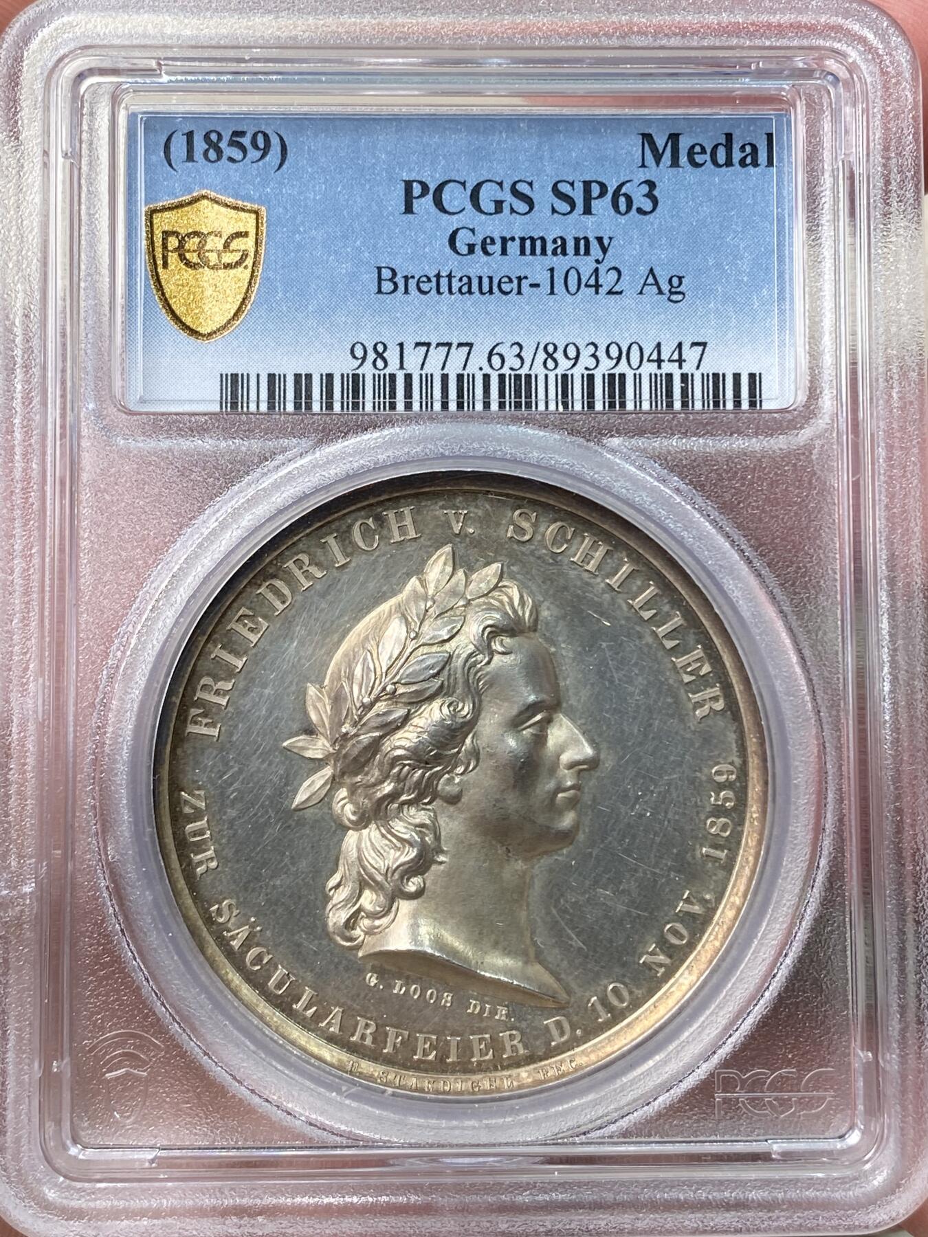 万国钱币拍卖第058期（万国新年大拍） PCGS MS63 1859年德国席勒诞辰百年纪念银章 PC唯一评级记录冠军分 稀见品种 43mm 28.8g 精制工艺强镜面，超高浮雕加厚盒。loos工坊大师炫技之作。雕刻细节极佳，人物栩栩如生。实物非常漂亮。正面:桂冠诗人席勒头像。背面:带翼缪斯女神手里拿着竖琴在天空飞行，13颗星星环绕。圣灵守护我们，灵魂也在其中徘徊。天使小翅膀灵动可爱又迷人。欧盟的盟歌欢乐颂为席勒于1785年创作的诗歌。