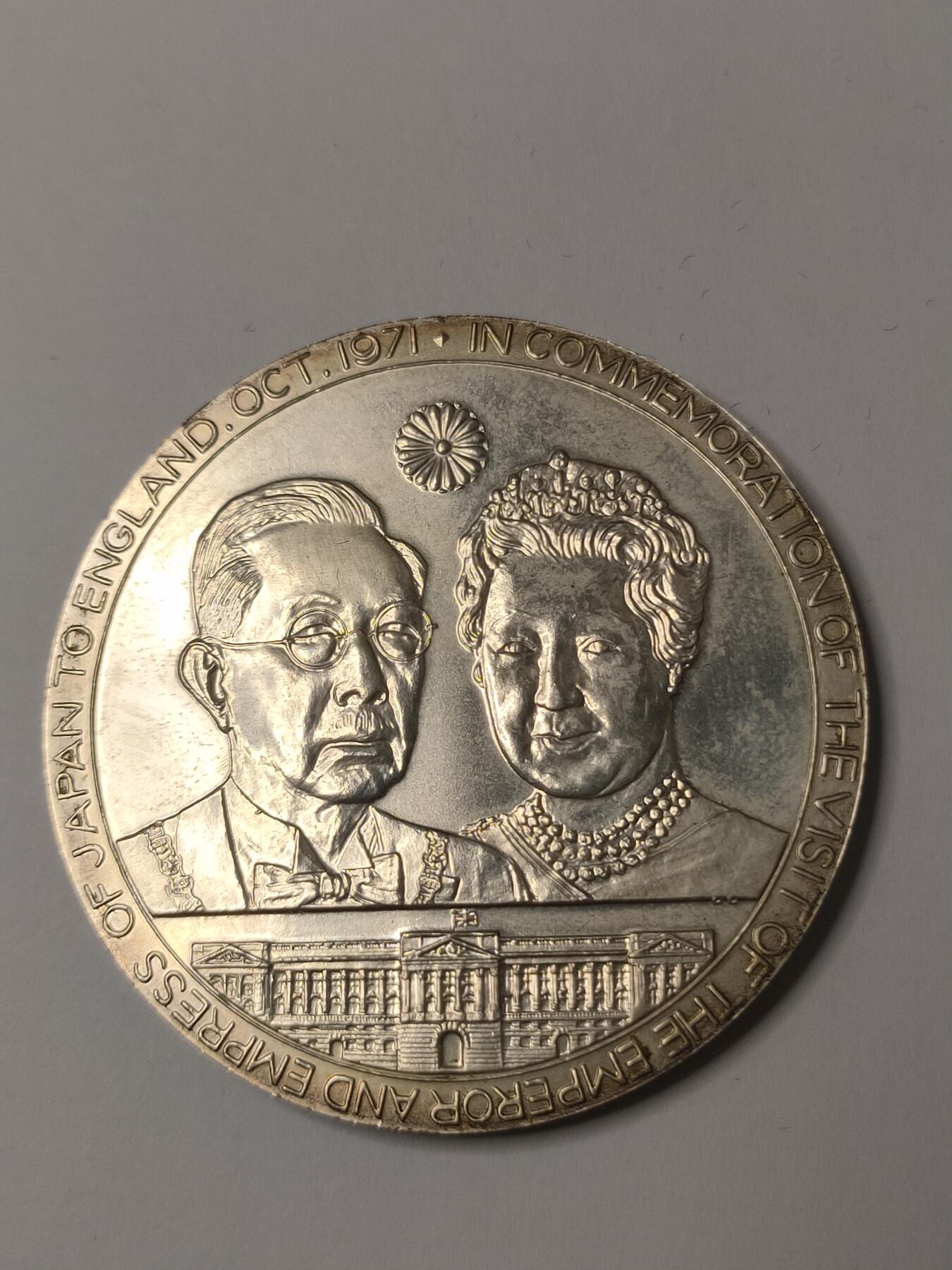 银质纪念章，直径约60mm，重约62克，带原装盒。正面为英国女王伊丽莎白二世和爱丁堡公爵，背面为日本天皇和皇后，纪念1971年日本天皇夫妇访问英国。银质材质，浮雕工艺，细节清晰，保存状态极佳，几乎全新，原配盒无明显磨损