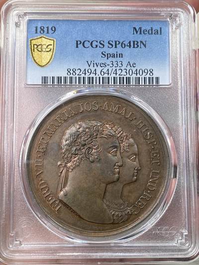 万国钱币拍卖第058期（万国新年大拍） PCGS SP64 1819年西班牙国王皇家婚礼原铸铜章 PC数据库唯一冠军。费迪南德七世，紫铜色包浆，高浮雕底板完美，44mm大尺寸厚实巧克力。正面是费迪南德和玛丽亚半身像，反面是圣坛前的手持祝福花环的美惠三女神，天使丘比特手持火炬。王室夫妇双手与上帝之手紧紧相握。两面均采用精心的艺术设计，具有动感和表现力的细节。明亮的铜色表面充分反射光线，实物很漂亮。