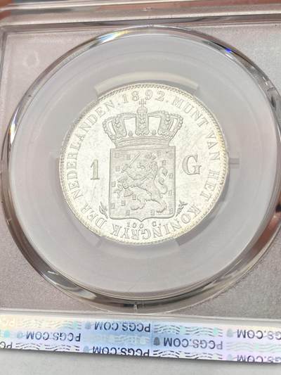 万国钱币拍卖第058期（万国新年大拍） PCGS MS64+ 1892年荷兰威廉明娜女王少女头像一盾银币 人见人爱的小萝莉。车轮霜光，打制极佳。底板类镜面质感，优异状态无愧一个加号，BU级别越来越难碰到了。瑞士拍卖NGSA刚拍的一枚66分到手约合RMB九万元。大热门品种，潜力十足，自藏级佳品。