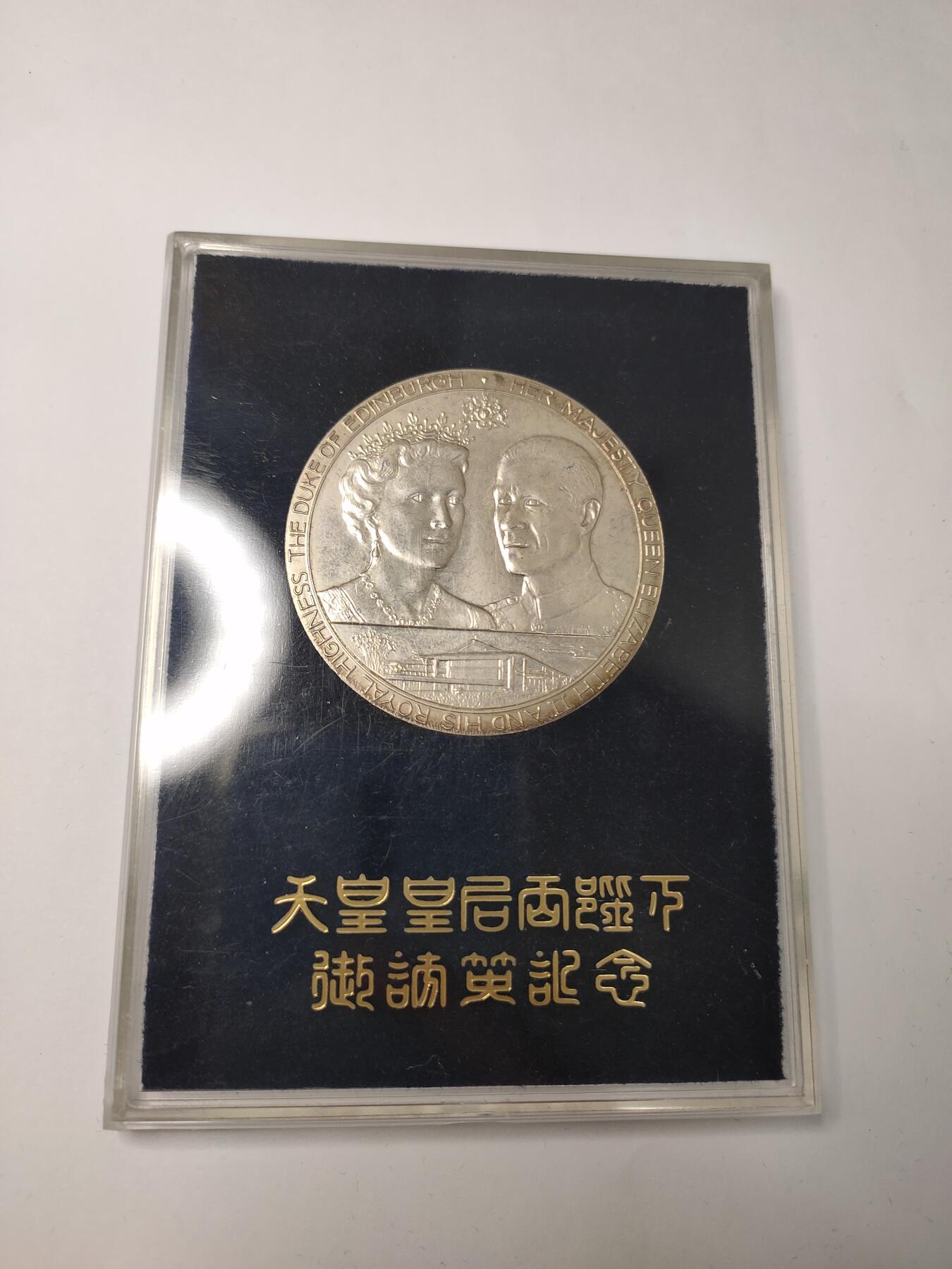 银质纪念章，直径约60mm，重约62克，带原装盒。正面为英国女王伊丽莎白二世和爱丁堡公爵，背面为日本天皇和皇后，纪念1971年日本天皇夫妇访问英国。银质材质，浮雕工艺，细节清晰，保存状态极佳，几乎全新，原配盒无明显磨损