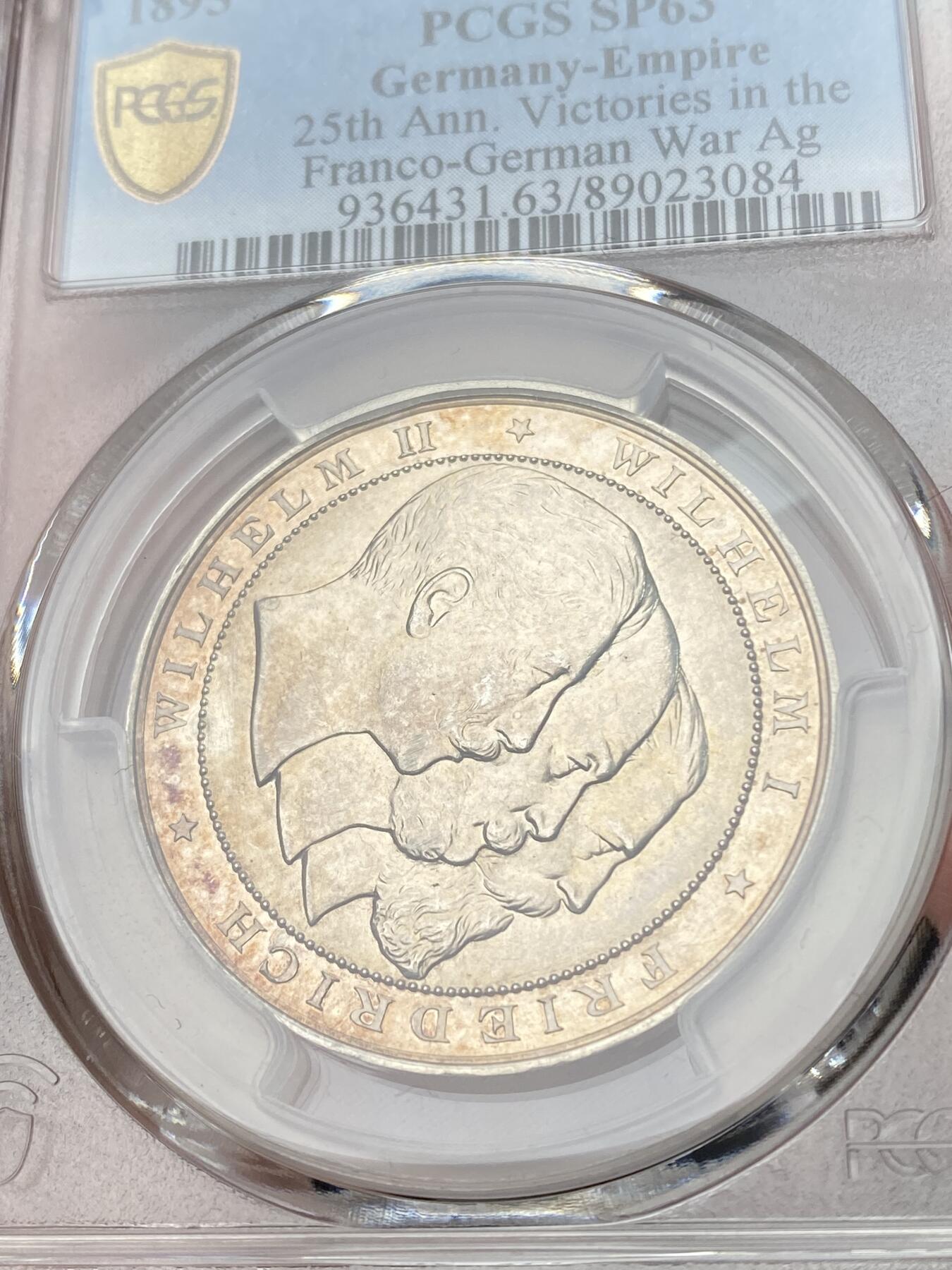 万国钱币拍卖第058期（万国新年大拍） PCGS SP63 1895年德国普法战争胜利25周年纪念三皇银章 正面:德意志帝国三皇头像，威廉一世，弗里德里希三世，威廉二世。背面:德意志神鹰，帝国盾徽和铁十字勋章。帝国鹰翅膀羽毛上雕刻着普法战争中重要的战役地点。内圈磨砂，外圈精制强镜面。高浮雕，金彩包浆。设计极佳，德味十足。