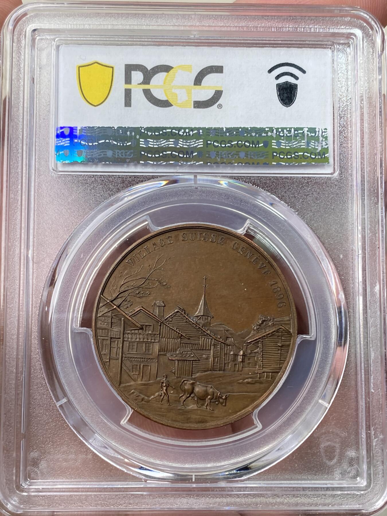 万国钱币拍卖第058期（万国新年大拍） PCGS SP66 1896年瑞士日内瓦射击节暨国家博览会瑞士村纪念铜章 正面:持弓弩的男子向右瞄准，背景为葱郁森林和绵延山脉。背面:农夫和耕牛往右走去，背景为村庄的街景。小树发新芽，预示着春天归来。冠军分官网封面章，高浮雕顶级状态。迷人的红棕色光泽，实物非常漂亮。极罕见瑞射形制，自藏佳品。