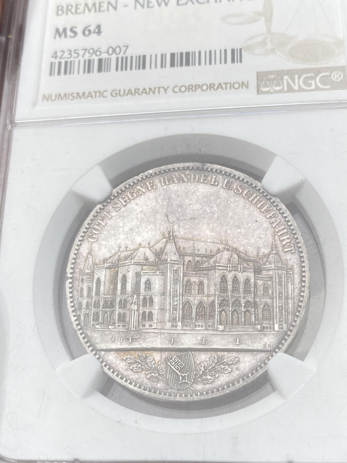 万国钱币拍卖第058期（万国新年大拍） NGC MS64 1864年不莱梅证券交易所泰勒 不莱梅自由市名誉品种 汉诺威造币厂精工之作 为庆祝不莱梅交易所的成立而发行 发行量仅5000枚 高分越来越难的品种 优雅淡彩状态舒适 不莱梅市徽上方刊德文“上帝保佑贸易与航运”这座美丽的新哥特风格建筑在1943年毁于战火 庆幸的是还能在此币上欣赏她的美丽