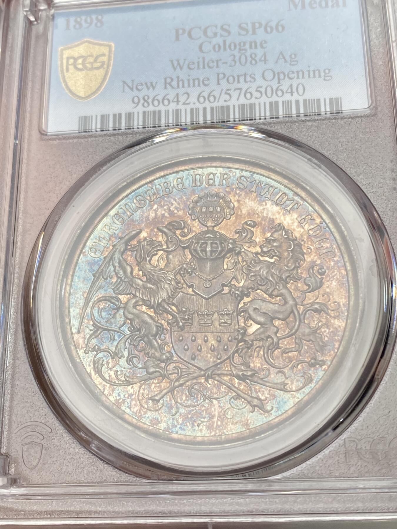 万国钱币拍卖第058期（万国新年大拍） PCGS SP66 1898年德国圣城科隆新港口开放典礼纪念大银章 欧洲紫罗兰渐变彩虹色包浆 科隆城市纹章在币章中出现不多 此枚将圣城狮鹫+雄狮盾徽完美具象化 非常难得和少见 镜面五彩高浮雕GEM典藏级 PC唯一冠军分 40MM 22G