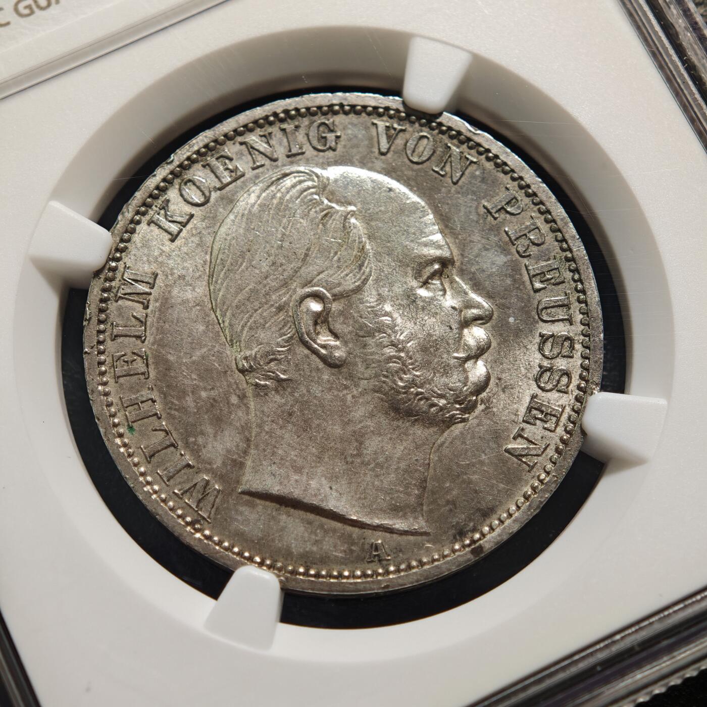 【德藏】世界币章拍卖第159期(元旦专场拍卖) 1867年 德国普鲁士威廉一世泰勒银币 NGC MS63 原味淡包浆不失原光 这枚属于德意志关税同盟泰勒体系，1857年德意志关税同盟确定该银币为统一流通货币，含银量为16.66克（900银），“XXX EIN PFUND FEIN”表示30枚该银币含1磅纯银“VEREINSTHALER”即“联合泰勒”1867年正值北德意志邦联成立这枚是普鲁士主导德意志统一进程中的流通货币,兼具经济与历史象征意义