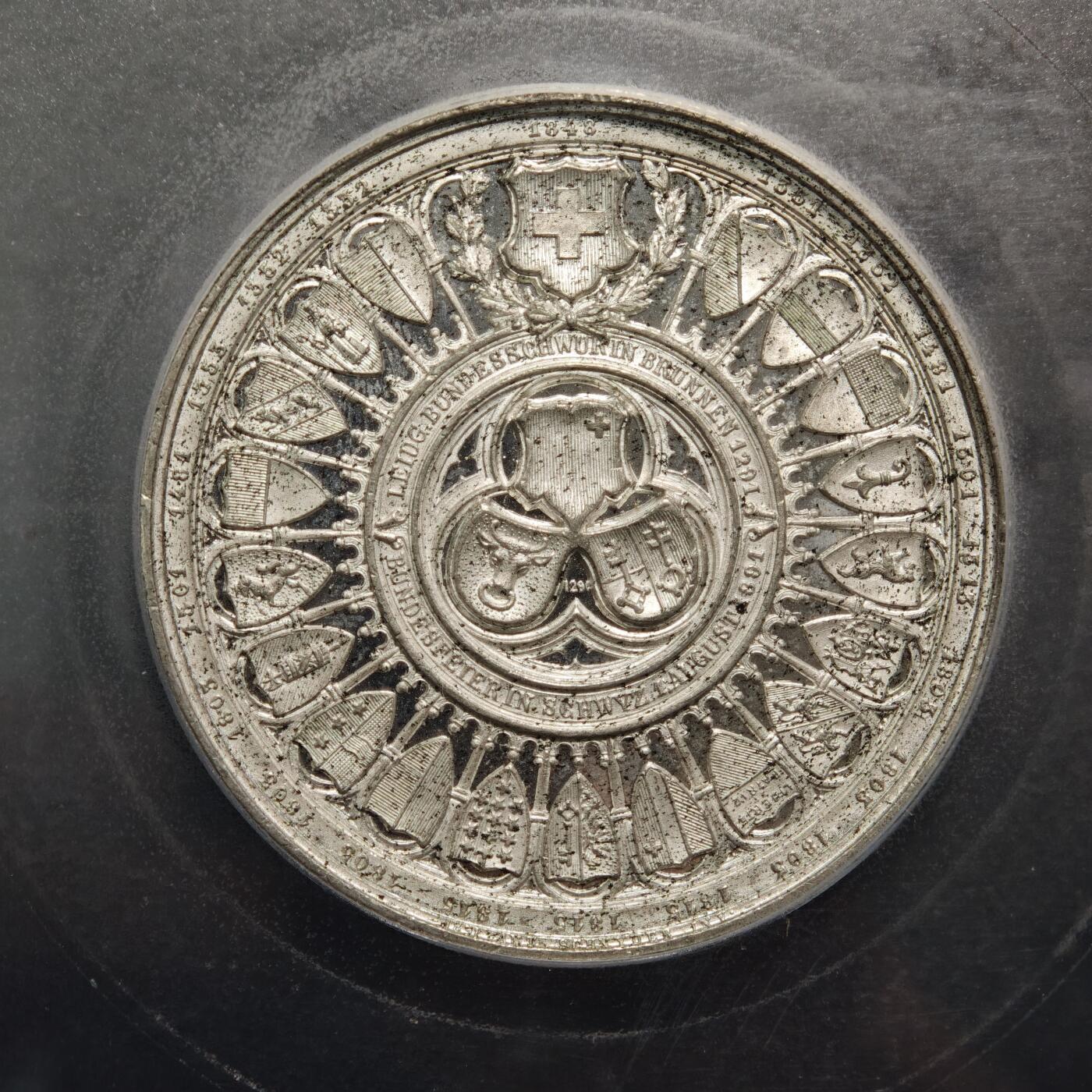 【德藏】世界币章拍卖第159期(元旦专场拍卖) 1891年 瑞士联邦成立600周年纪念合金大章，直径50毫米，PCGS SP62分 正面是瑞士联邦徽章和环绕的各州纹章，背面是手持棕榈枝、桂枝的天使祝贺和三个州代表结盟宣誓的场景以及湖泊房屋山景的图案。雕刻精美，品相完好，镜面效果