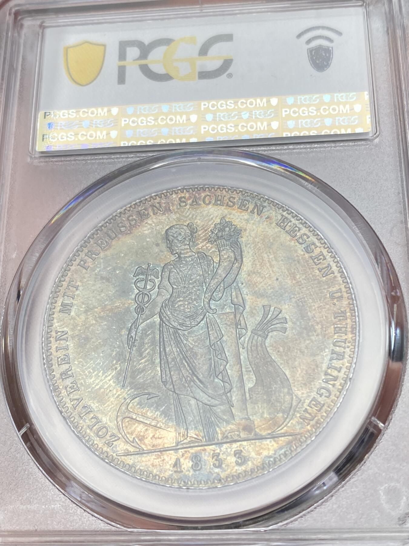 万国钱币拍卖第058期（万国新年大拍） PCGS MS64 1833巴伐利亚路德维希一世关税同盟历史大泰勒 在历史泰勒四枚关税同盟系列中好品最为罕见的品种 人格化的巴伐利亚女神着一席长袍 左手举丰饶角 右手持墨丘利权杖 寓意新的关税同盟带来贸易与财富 双面厚重油画五彩 顶级典藏品质