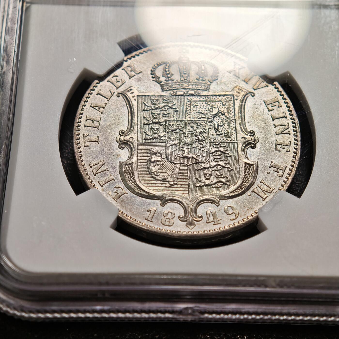 【德藏】世界币章拍卖第159期(元旦专场拍卖) 1849年 德国汉诺威恩斯特·奥古斯特泰勒银币 NGC MS61 淡包浆 状态十足 背面汉诺威王国的纹章（带有皇冠的盾徽），盾徽融合了汉诺威、大不列颠等多地的徽章元素，体现了汉诺威与英国的王室亲缘关系（恩斯特·奥古斯特是英国乔治三世的儿子）