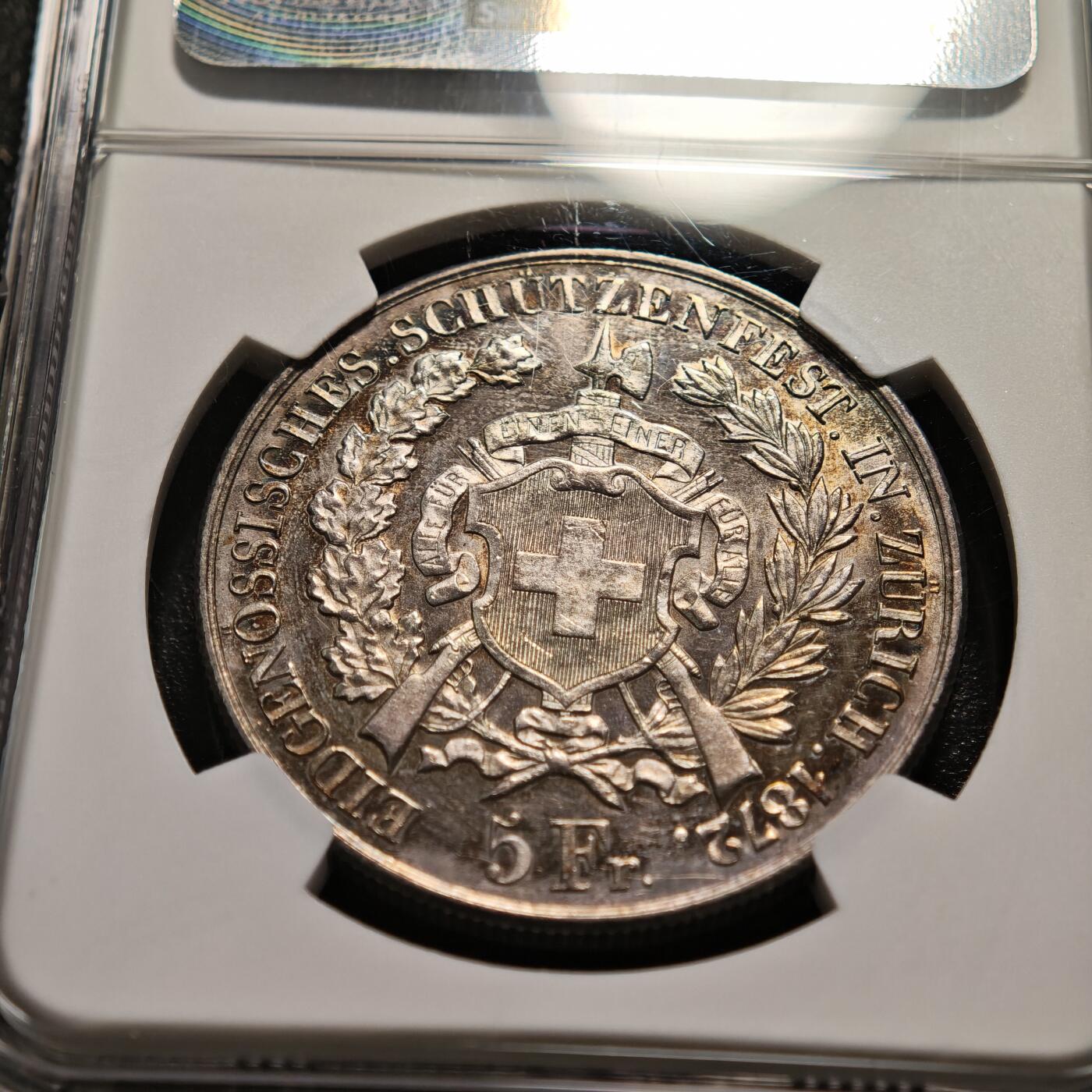 【德藏】世界币章拍卖第159期(元旦专场拍卖) 1872年 瑞士苏黎世射击节5法郎大银币，发行量仅1万枚 NGC MS61 正面是瑞士自由女神一手高举桂冠、一手扶着盾牌的站立像，背面是瑞士盾牌和射击节徽章，雕刻精美，保存状态良好，五彩包浆，稀少品种，NGC低评