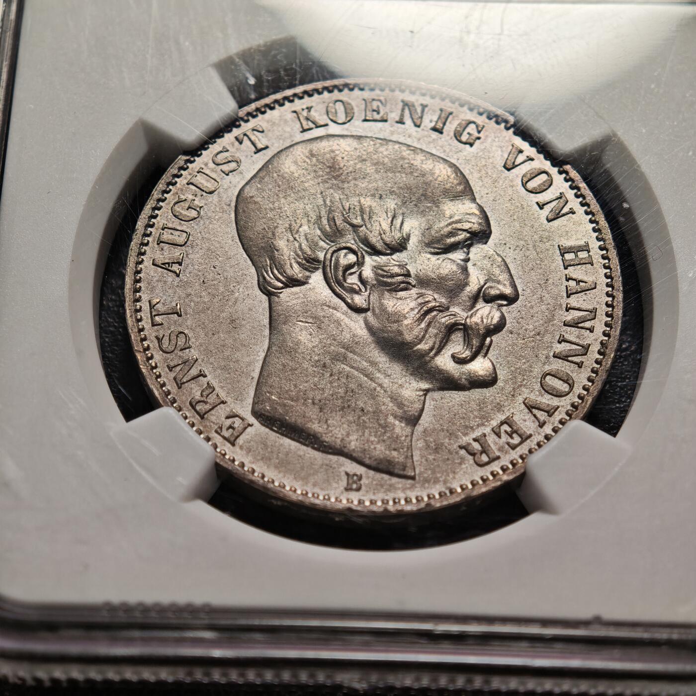 【德藏】世界币章拍卖第159期(元旦专场拍卖) 1849年 德国汉诺威恩斯特·奥古斯特泰勒银币 NGC MS61 淡包浆 状态十足 背面汉诺威王国的纹章（带有皇冠的盾徽），盾徽融合了汉诺威、大不列颠等多地的徽章元素，体现了汉诺威与英国的王室亲缘关系（恩斯特·奥古斯特是英国乔治三世的儿子）