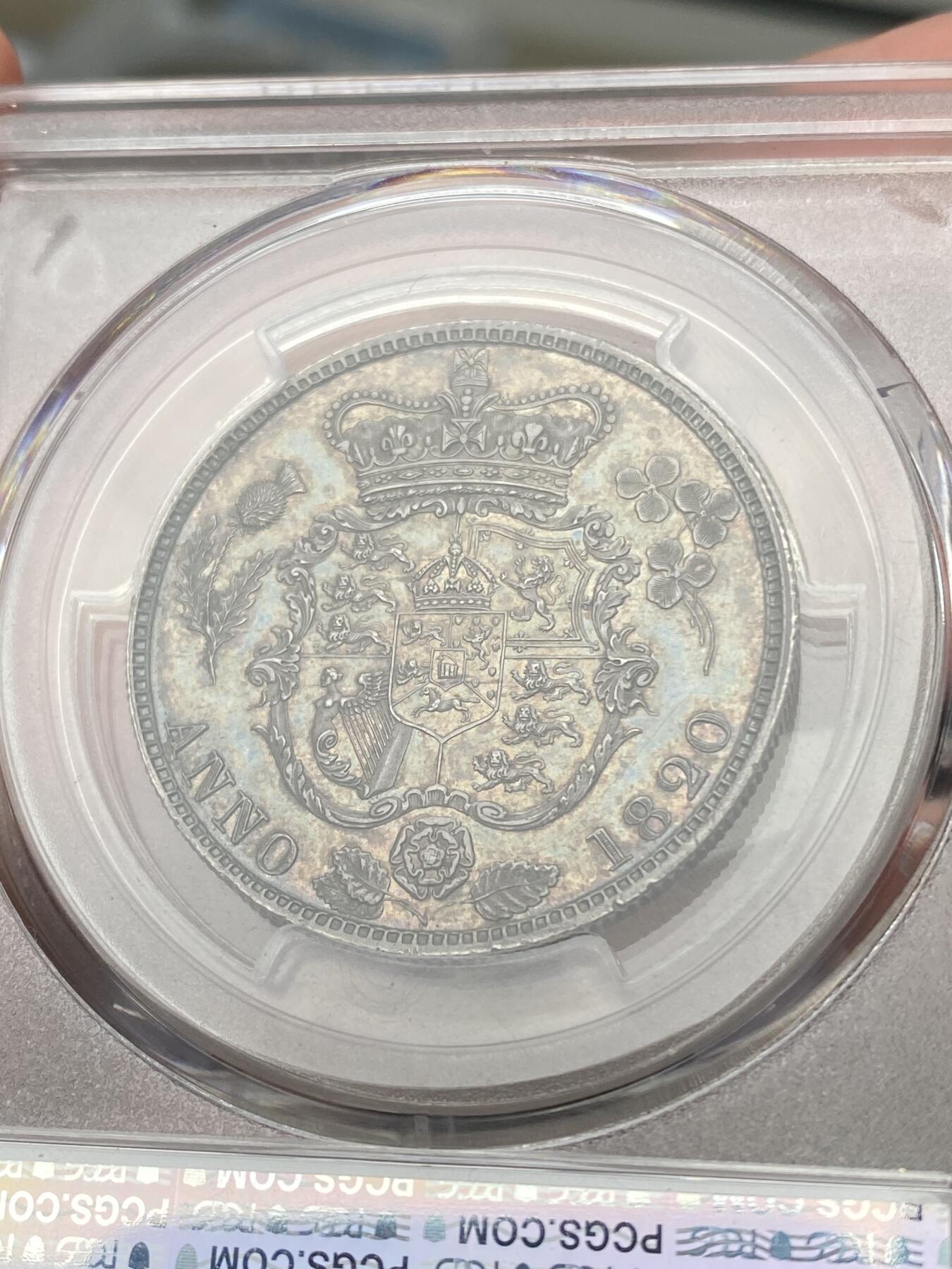 万国钱币拍卖第058期（万国新年大拍） PCGS PR64 1820英国乔治四世三花精制半克朗 极其罕见的精制版本 一颗精雕细琢的艺术品 象征英格兰的玫瑰，苏格兰的蓟草和爱尔兰的三叶草三位一体的围绕在汉诺威王朝的盾徽周围 将乔治四世时期的装饰艺术体现的淋漓尽致 在精制工艺的加持下更显华丽 双面英式乌云五彩镜面底板 顶级典藏品质