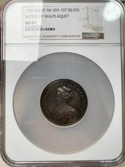 万国钱币拍卖第058期（万国新年大拍） NGC MS61 1709年英国安妮女王马尔普拉奎特战役纪念大银章 不列颠尼亚在天空中祝福军队 左边的发过军队在向进攻中的盟军开炮 宏大的英系早期战争场景刻画 细腻生动的细节刻画令人惊叹 原味黑彩收藏级品质（盒子背面有划痕）