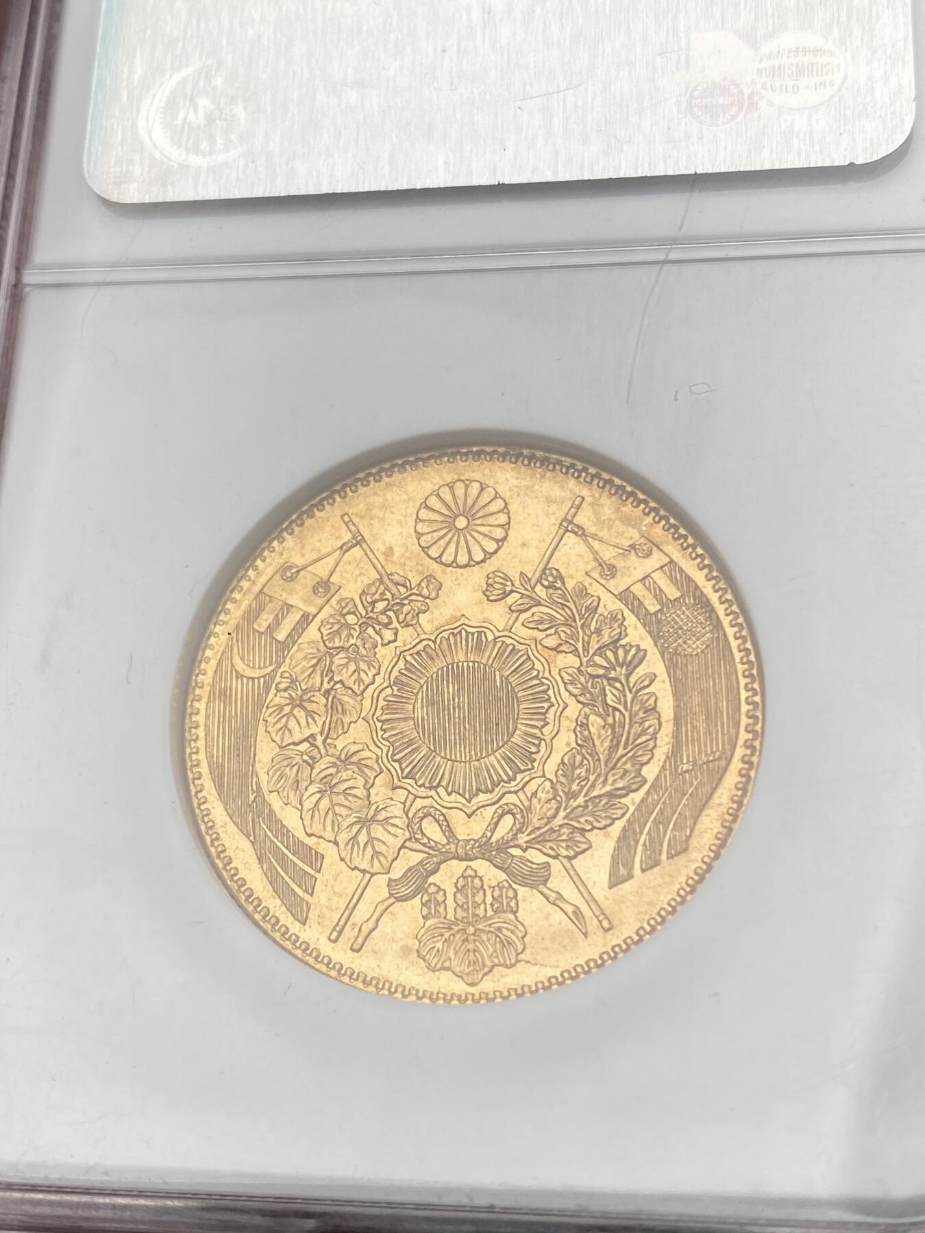 万国钱币拍卖第058期（万国新年大拍） NGC MS64 1871年日本明治四年双旗旧十円大金币 日系经典名誉品种 大阪造币厂铸 背面中央是日本传统神话中三神器之一的八尺镜 上方是象征日本皇室的十六瓣八重表菊纹 两边则是象征天照与月读大神的旗帜 也是明治四年发行货币中的最大面值 打制深峻丝绸金光轻微类镜面质感 NGC老白盒顶级收藏品质 16.66G 900金 