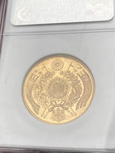 万国钱币拍卖第058期（万国新年大拍） NGC MS64 1871年日本明治四年双旗旧十円大金币 日系经典名誉品种 大阪造币厂铸 背面中央是日本传统神话中三神器之一的八尺镜 上方是象征日本皇室的十六瓣八重表菊纹 两边则是象征天照与月读大神的旗帜 也是明治四年发行货币中的最大面值 打制深峻丝绸金光轻微类镜面质感 NGC老白盒顶级收藏品质 16.66G 900金 