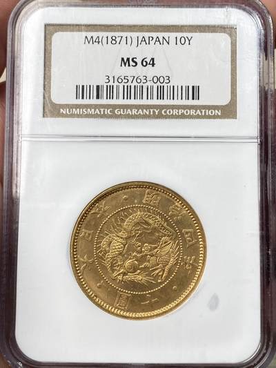 万国钱币拍卖第058期（万国新年大拍） - NGC MS64 1871年日本明治四年双旗旧十円大金币 日系经典名誉品种 大阪造币厂铸 背面中央是日本传统神话中三神器之一的八尺镜 上方是象征日本皇室的十六瓣八重表菊纹 两边则是象征天照与月读大神的旗帜 也是明治四年发行货币中的最大面值 打制深峻丝绸金光轻微类镜面质感 NGC老白盒顶级收藏品质 16.66G 900金 