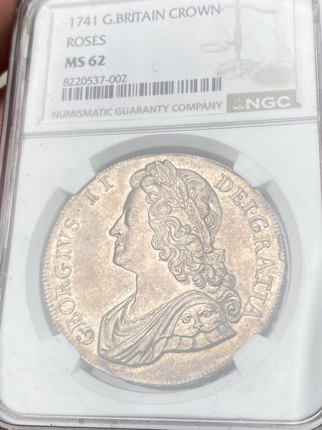 万国钱币拍卖第058期（万国新年大拍） NGC MS62 1741英国乔治二世玫瑰克朗 英国克朗系列中的大名誉品种 早期青年版头像 来自十八世纪中期的巅峰工艺 深峻的打制让你不会错过任何一个高点细节 玫瑰与纹章的设计在双面香槟金彩的加持下尽显雍容 不同错过的顶级收藏品质