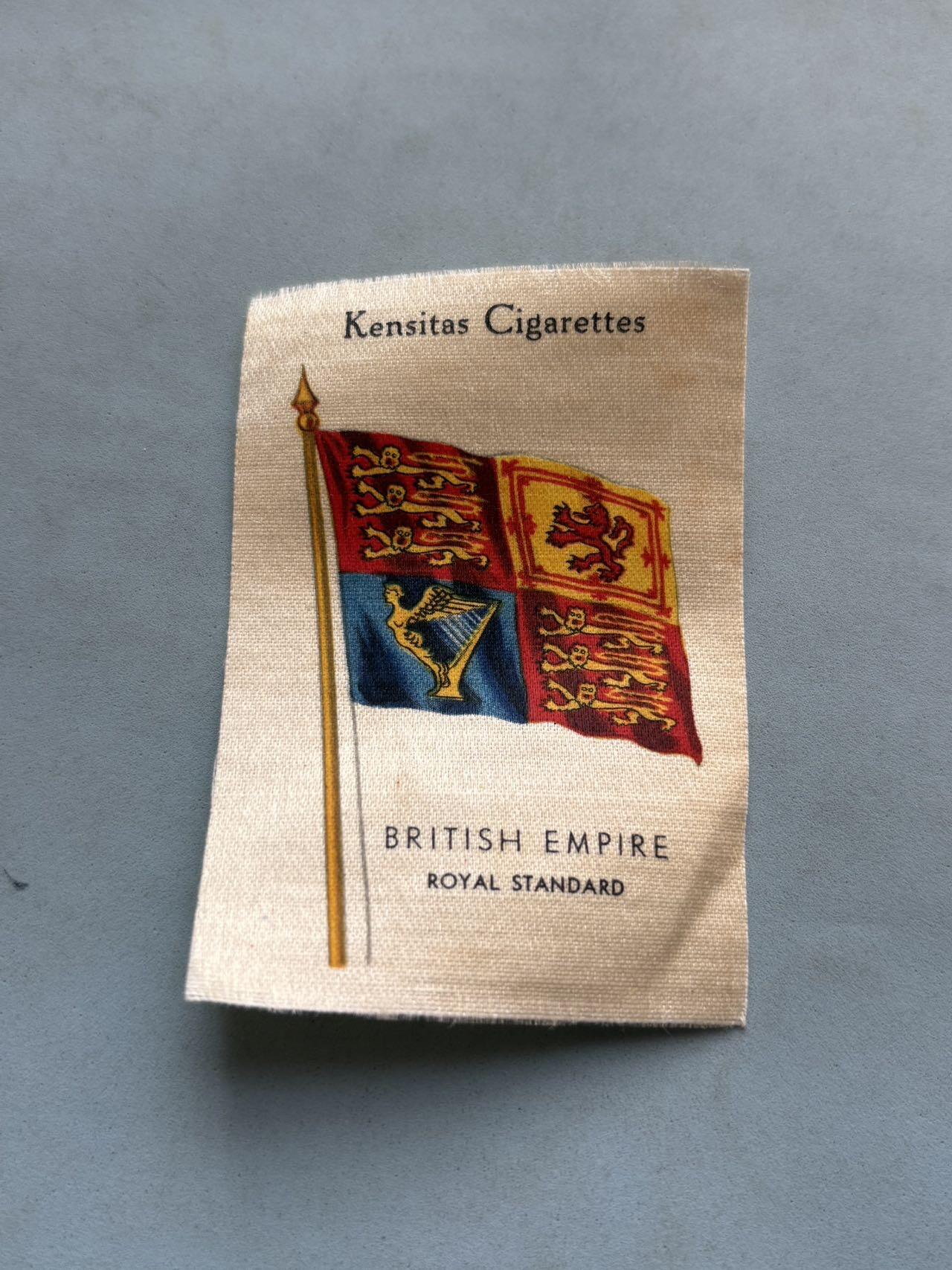 盛世勋华——号角文化勋章邮票专场拍卖第297期 1934年大英帝国王室旗主题丝绸收藏卡，British Empire Royal Standard（大英帝国皇家旗） 是英国君主的专属旗帜，图案由四个象限构成：第一/第四象限为代表英格兰的三头金狮、第二象限为代表苏格兰的红狮、第三象限为代表爱尔兰的金色竖琴，威尔士因早于英苏爱合并成为公国，未在旗面体现