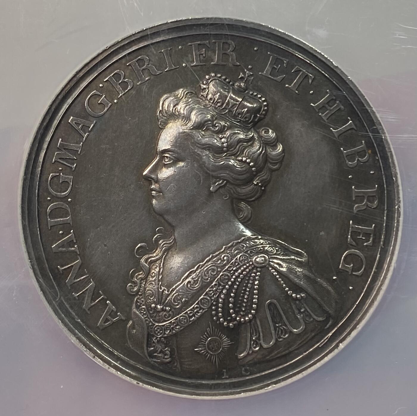 万国钱币拍卖第058期（万国新年大拍） NGC MS61 1709年英国安妮女王马尔普拉奎特战役纪念大银章 不列颠尼亚在天空中祝福军队 左边的发过军队在向进攻中的盟军开炮 宏大的英系早期战争场景刻画 细腻生动的细节刻画令人惊叹 原味黑彩收藏级品质（盒子背面有划痕）