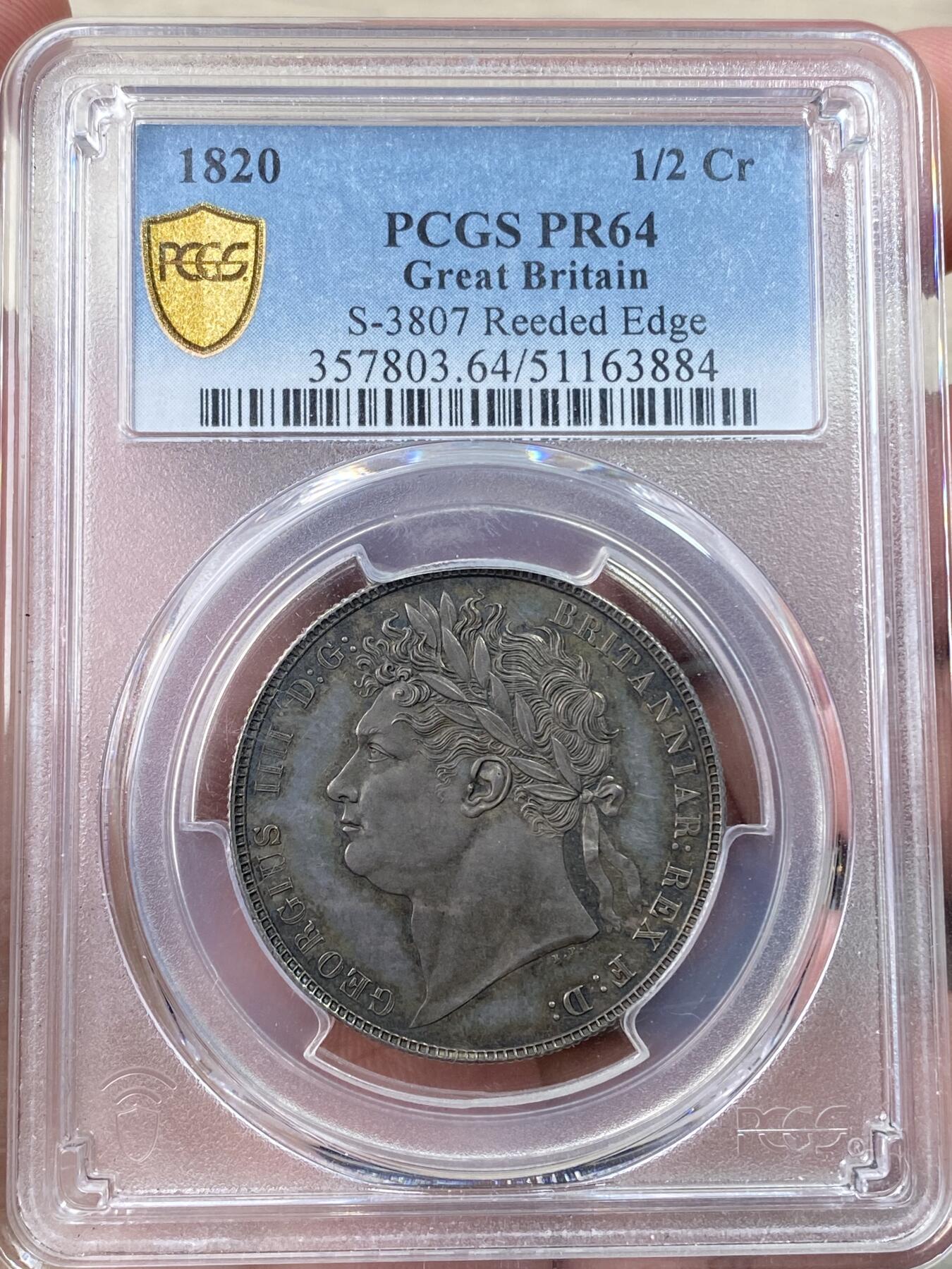万国钱币拍卖第058期（万国新年大拍） PCGS PR64 1820英国乔治四世三花精制半克朗 极其罕见的精制版本 一颗精雕细琢的艺术品 象征英格兰的玫瑰，苏格兰的蓟草和爱尔兰的三叶草三位一体的围绕在汉诺威王朝的盾徽周围 将乔治四世时期的装饰艺术体现的淋漓尽致 在精制工艺的加持下更显华丽 双面英式乌云五彩镜面底板 顶级典藏品质