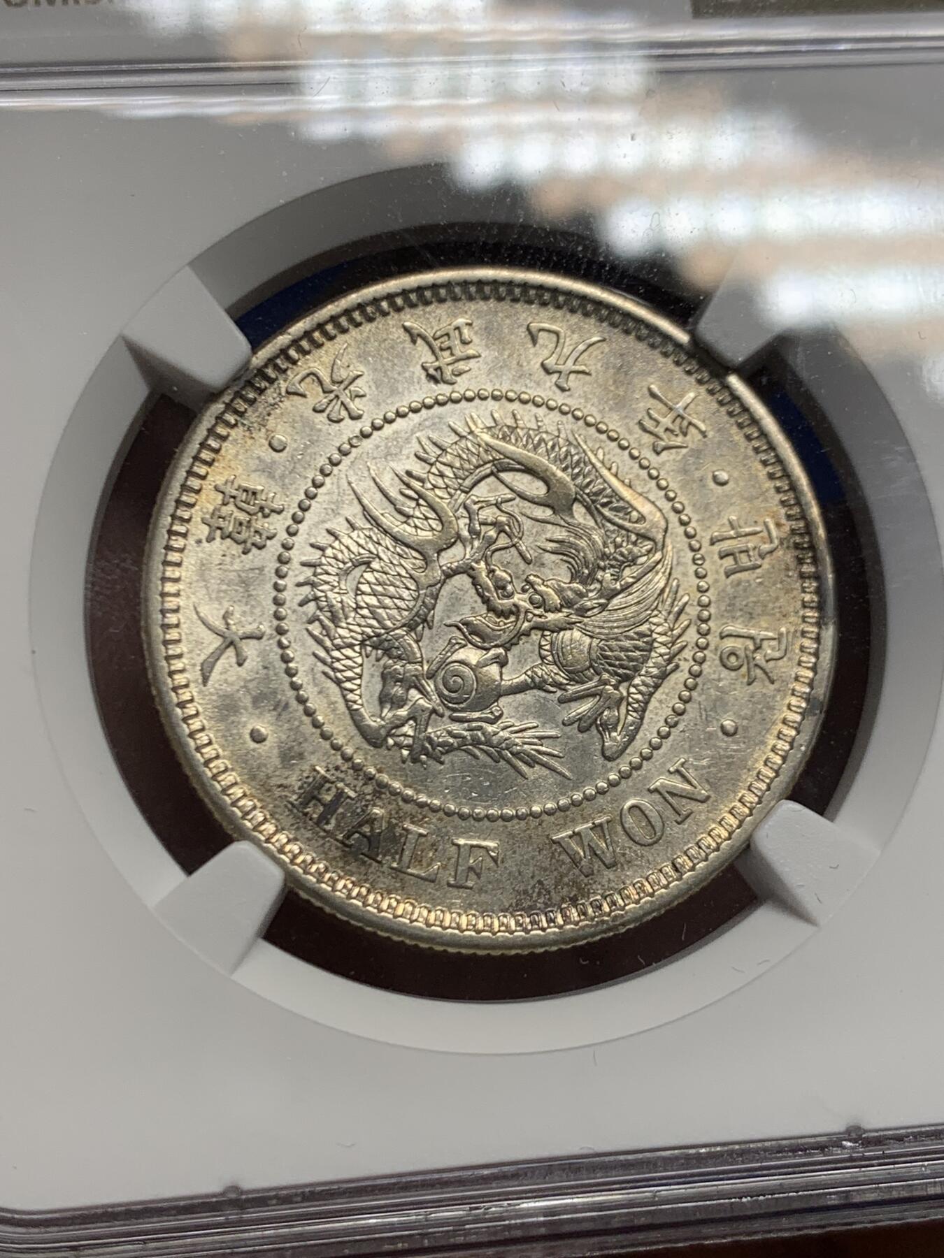 《竞宝斋》第453场 周日，周一 2场连拍 （全场包邮，欢迎送拍） NGC AU55 朝鲜1905年光武九年半圆银币 原味自然老彩，正面蟠龙戏珠图，龙身盘踞如环，背面上方为“李花章”（五瓣木槿花），下方交叉的桔梗花（左）与李花（右），些许低评