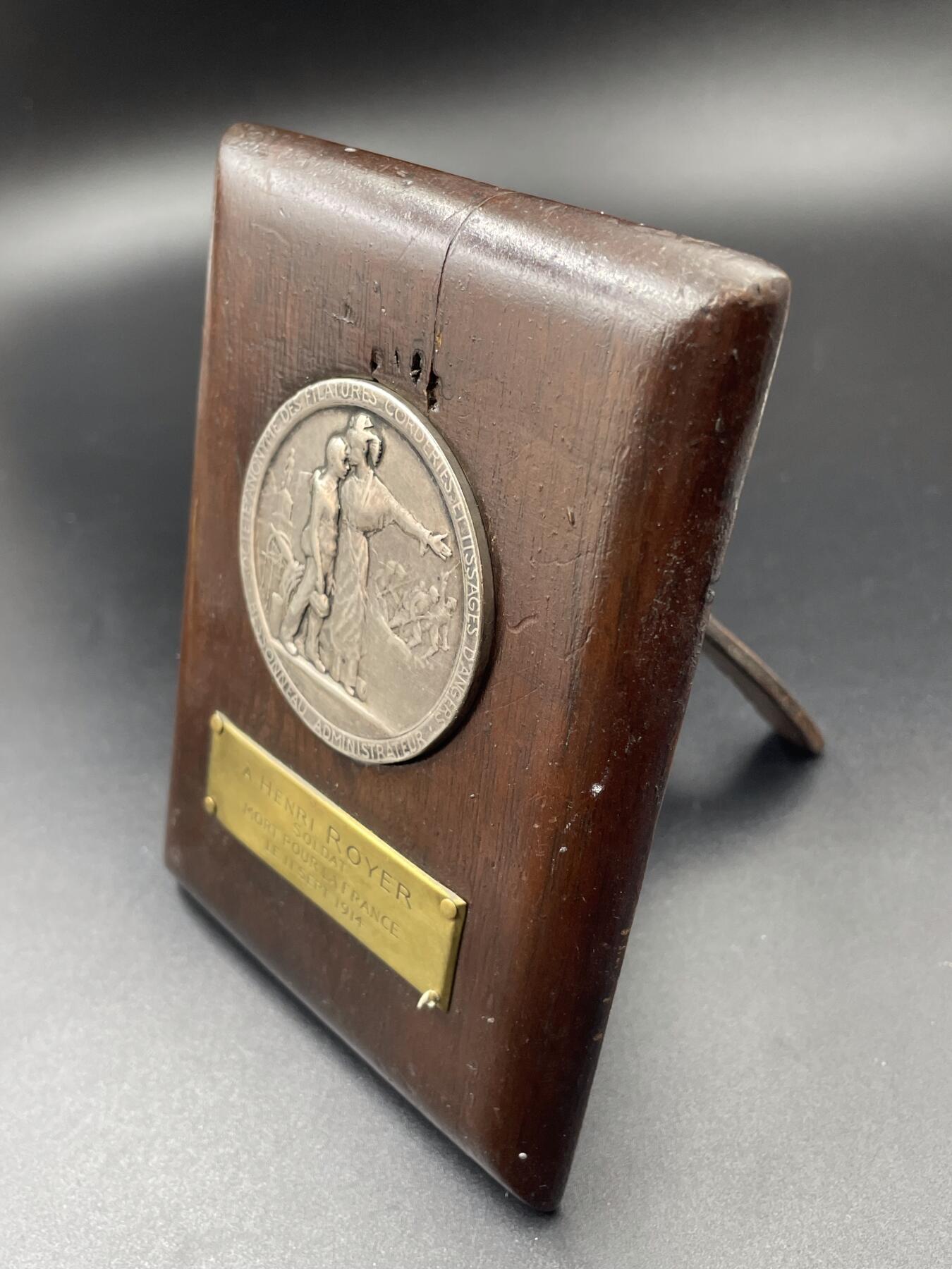 「木头集藏」章牌专场-第65场 1914年法国一战爱国主义纪念银章，直径：50mm，56.2 g，边铭：菱形厂标 野猪头银标 ARGENT，背面刻有维克多·雨果《为法国而死》（Morts pour la France）中的诗句：“荣耀归于我们永恒的法兰西！荣耀归于为她牺牲的人们！致殉道者、勇者、强者，致那些被他们的榜样所激励，渴望在圣殿中拥有一席之地，并将如他们般赴死的人”。带有木质展示架，可正常使用。