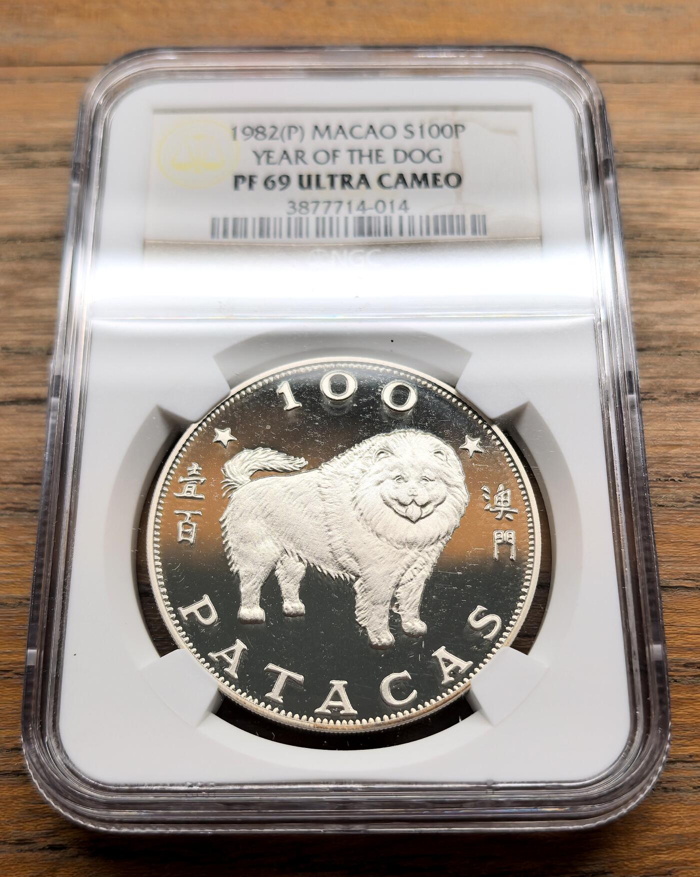 凡希社世界钱币微拍第三百十六期 1982中国澳门生肖狗100元大银精铸NGC-PF69UC，白色印痕在外盒上，币面完美。
