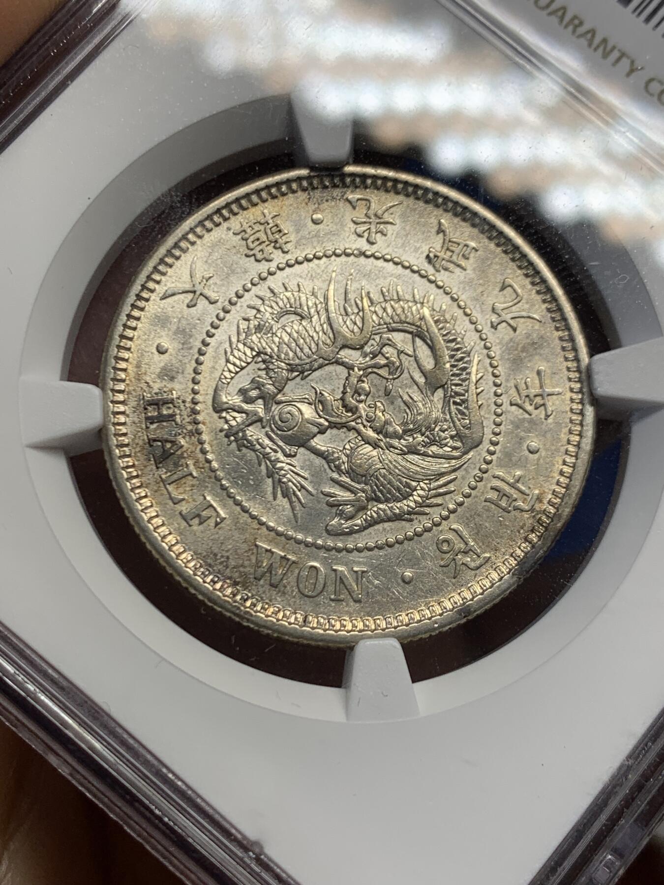 《竞宝斋》第453场 周日，周一 2场连拍 （全场包邮，欢迎送拍） NGC AU55 朝鲜1905年光武九年半圆银币 原味自然老彩，正面蟠龙戏珠图，龙身盘踞如环，背面上方为“李花章”（五瓣木槿花），下方交叉的桔梗花（左）与李花（右），些许低评