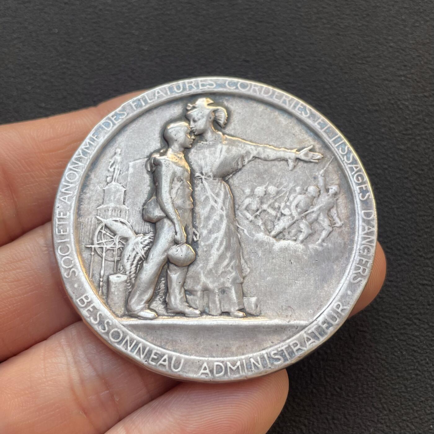 「木头集藏」章牌专场-第65场 1914年法国一战爱国主义纪念银章，直径：50mm，56.2 g，边铭：菱形厂标 野猪头银标 ARGENT，背面刻有维克多·雨果《为法国而死》（Morts pour la France）中的诗句：“荣耀归于我们永恒的法兰西！荣耀归于为她牺牲的人们！致殉道者、勇者、强者，致那些被他们的榜样所激励，渴望在圣殿中拥有一席之地，并将如他们般赴死的人”。带有木质展示架，可正常使用。