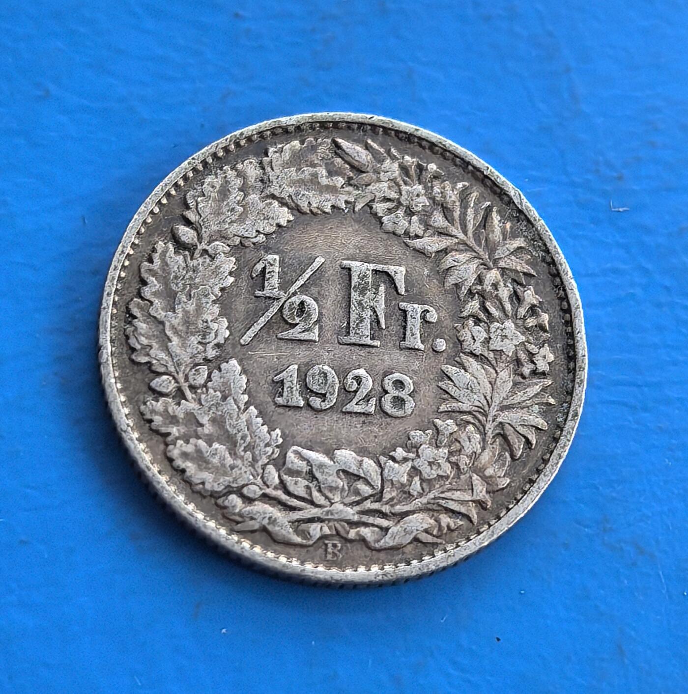 外国优质老铜币高银银币，周六九点倒数截拍，满百包邮，持续收拍 瑞士1928 年半法郎银币，正面海尔维蒂亚（瑞士象征）持盾立姿，环饰星芒；背面花团环绕 “1/2 Fr.”，雕刻细腻。银质铸于战后，见证中立国坚守，设计融联邦精神与美学。属瑞士经典币，为欧陆中立史、货币工艺收藏添独特标本，藏时代厚重与文化符号 。