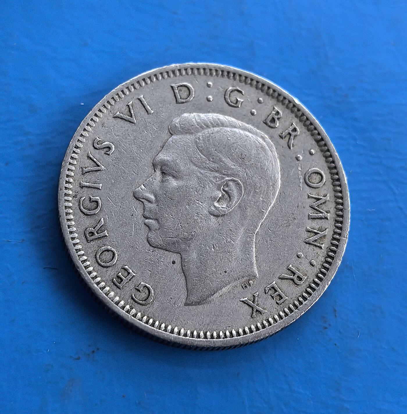 外国优质老铜币高银银币，周六九点倒数截拍，满百包邮，持续收拍 英国1949 年1先令，正面为乔治六世肖像，背面英格兰站狮踞皇冠，铭文承载王室符号。属战后流通币，铜镍材质留存岁月包浆，见证英帝国币制脉络。皇家纹章设计 + 特定历史节点，是钱币收藏触摸英王室历史与殖民时代的独特标的 。