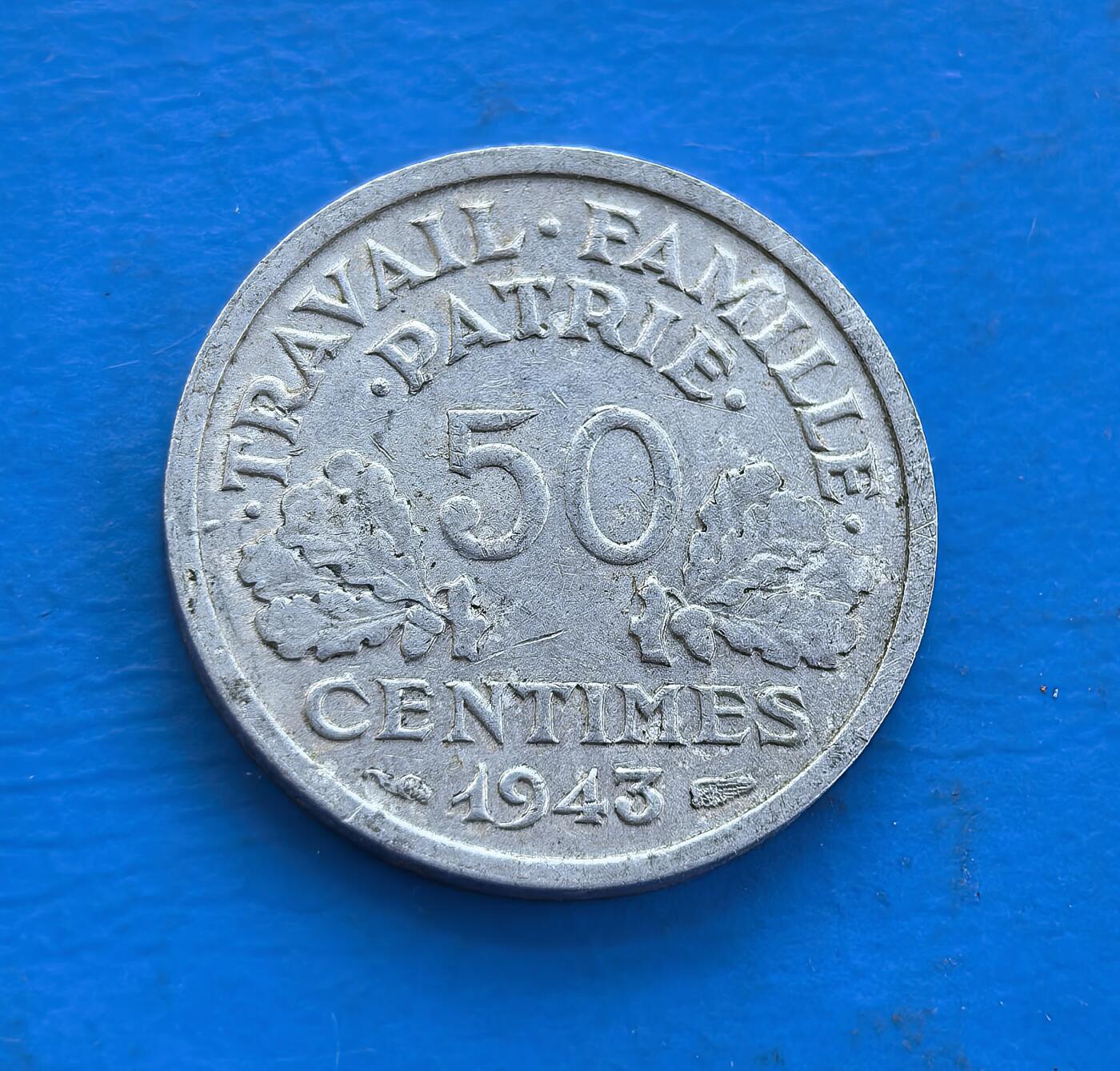 外国优质老铜币高银银币，周六九点倒数截拍，满百包邮，持续收拍 维希法国 1943 年50 分币，诞生于二战傀儡政权时期。正面斧与麦穗、背面 “工作・家庭・祖国”，凝萃维希符号。镍质包浆载战时痕，属特殊政权货币标本。解码法国二战分裂史，小众却藏时代矛盾，是研究战时政治、拓展收藏视野的独特标的，历史厚重与符号意趣交融 。
