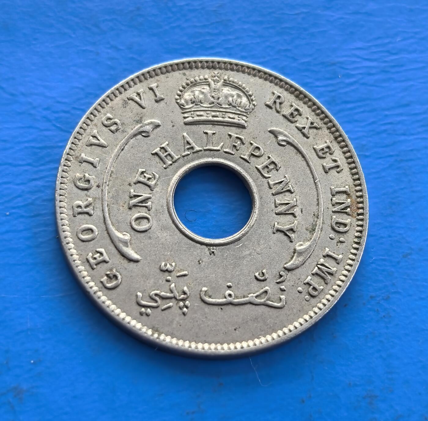 外国优质老铜币高银银币，周六九点倒数截拍，满百包邮，持续收拍 英属西非1947年半便士H版，中孔设计别致。正面集乔治六世王冠、王室铭文与阿拉伯文，背面六芒星分割纪年，融合殖民、宗教符号。诞生于二战后英殖民末期，见证帝国余晖，存世随岁月渐稀。作为多元文化碰撞的殖民币标本，解码西非历史，收藏兼具故事性与设计感 。