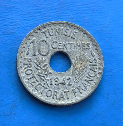 外国优质老铜币高银银币，周六九点倒数截拍，满百包邮，持续收拍 - 法属突尼斯 1942 年10 分圆孔币，诞生于二战烽火，见证殖民统治与文化交融。正面法语、背面阿拉伯文，圆孔形制独特。铜镍包浆载岁月痕迹，存世因战乱、政权更迭渐稀。属北非殖民币标本，解码法突文化碰撞，藏战争与殖民双重脉络，是触摸异域殖民史的独特标的 。
