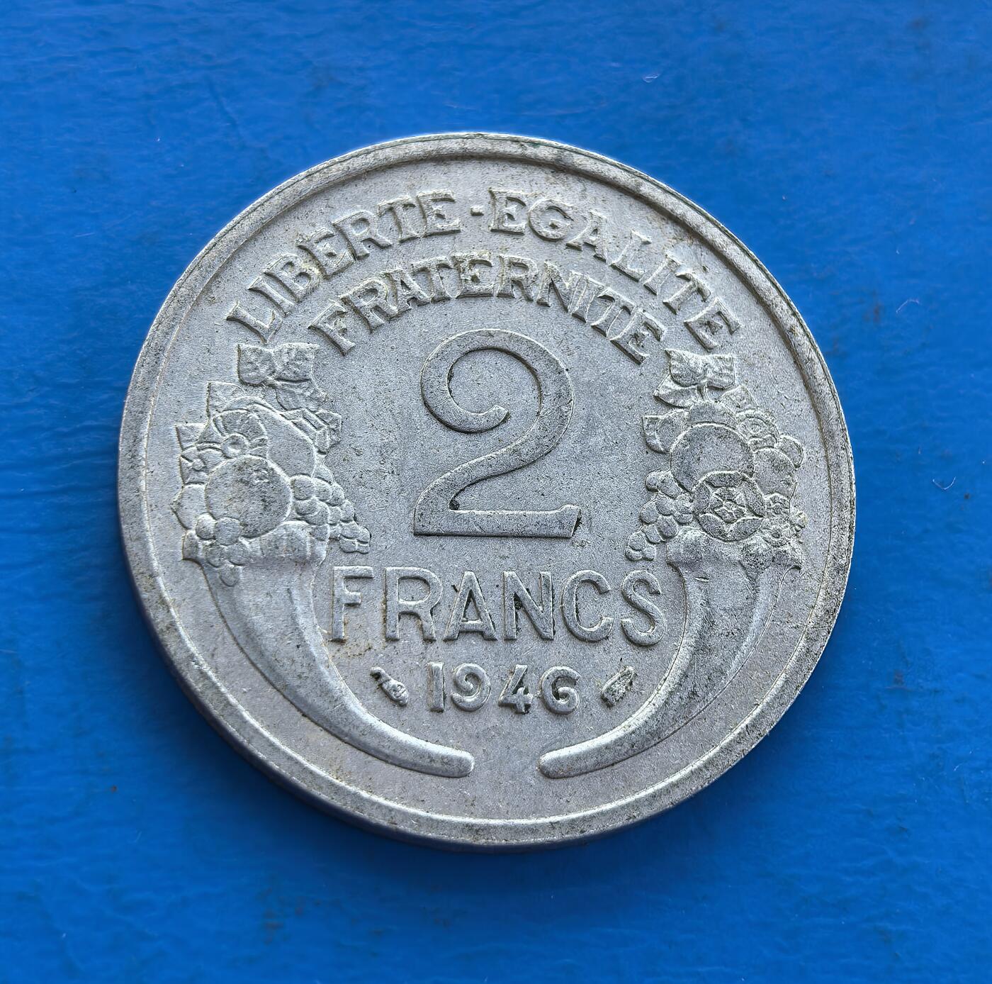 外国优质老铜币高银银币，周六九点倒数截拍，满百包邮，持续收拍 法国1946 年 2 法郎，诞生于二战后共和重建初期。正面玛丽安娜象征自由，背面 “自由・平等・博爱” 呼应启蒙精神，凝萃法兰西核心价值。镍质包浆载战后希望，见证国家从废墟重拾共和理念。作为战后转型货币标本，解码历史转折，收藏兼具时代意义与文化传承 。