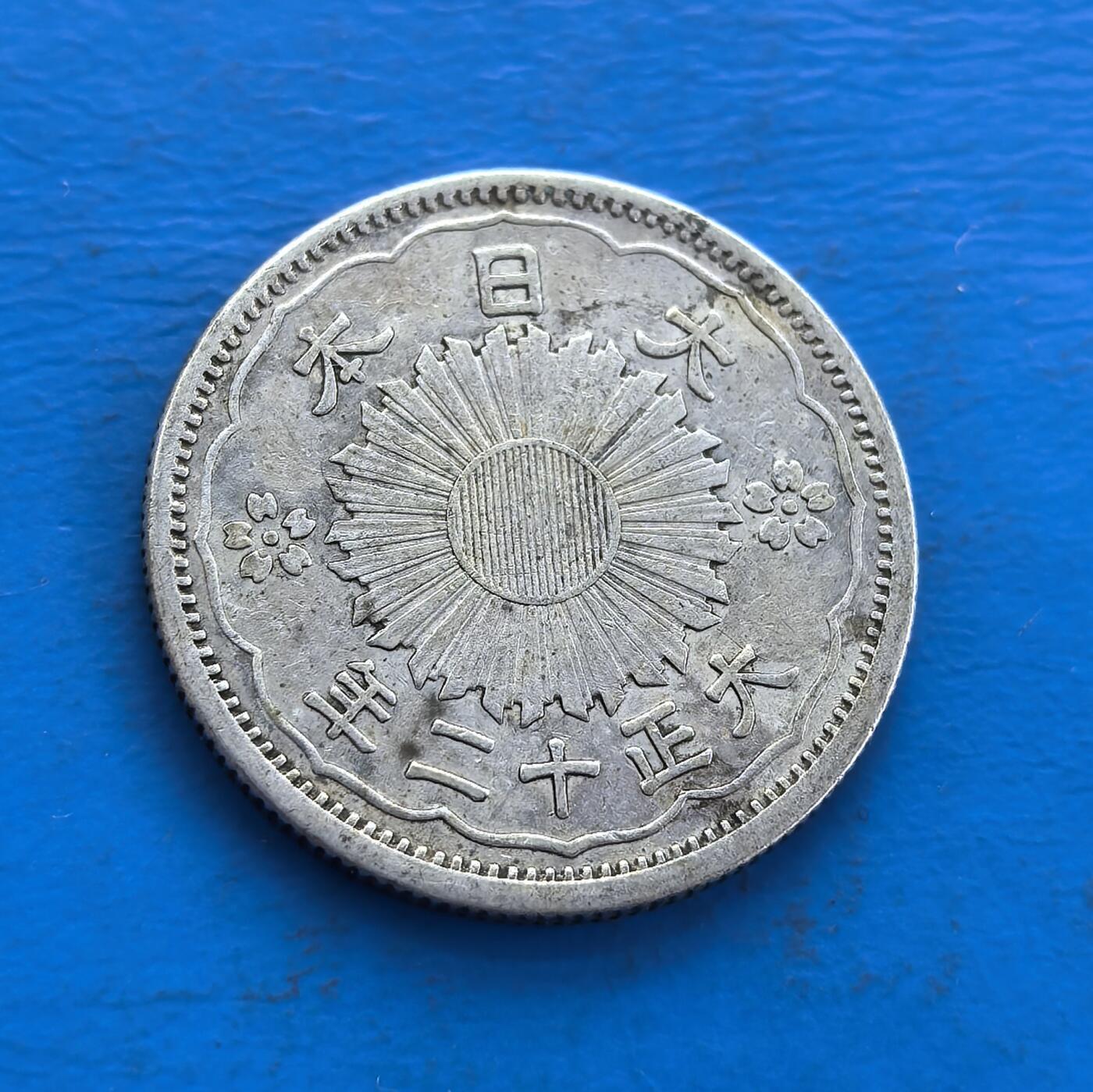 外国优质老铜币高银银币，周六九点倒数截拍，满百包邮，持续收拍 日本大正十二年（1923 年）五十钱银币，正面双凤衔枝环绕日章，背面菊花纹章配年号，银质温润。见证大正民主期货币美学，凤纹寓祥瑞，工艺融传统与近代铸币技。存世因岁月流通渐稀，承载东瀛货币文化脉络，是解码日本大正时代、收藏凤纹银币的独特标的 。